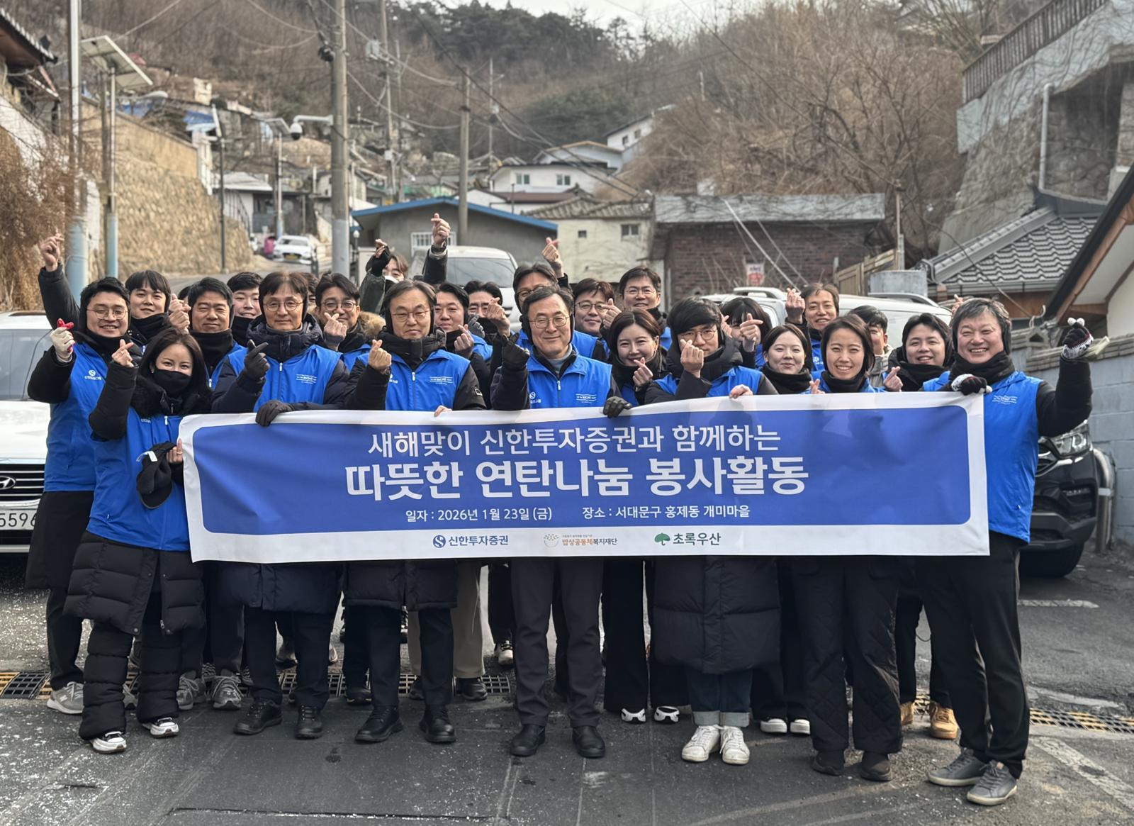 올해 1월 23일 신한투자증권 임직원들이 서울 서대문구 홍제동 개미마을에서 새해맞이 연탄나눔 봉사활동을 한 뒤 기념사진을 촬영하고 있다. 신한투자증권 제공