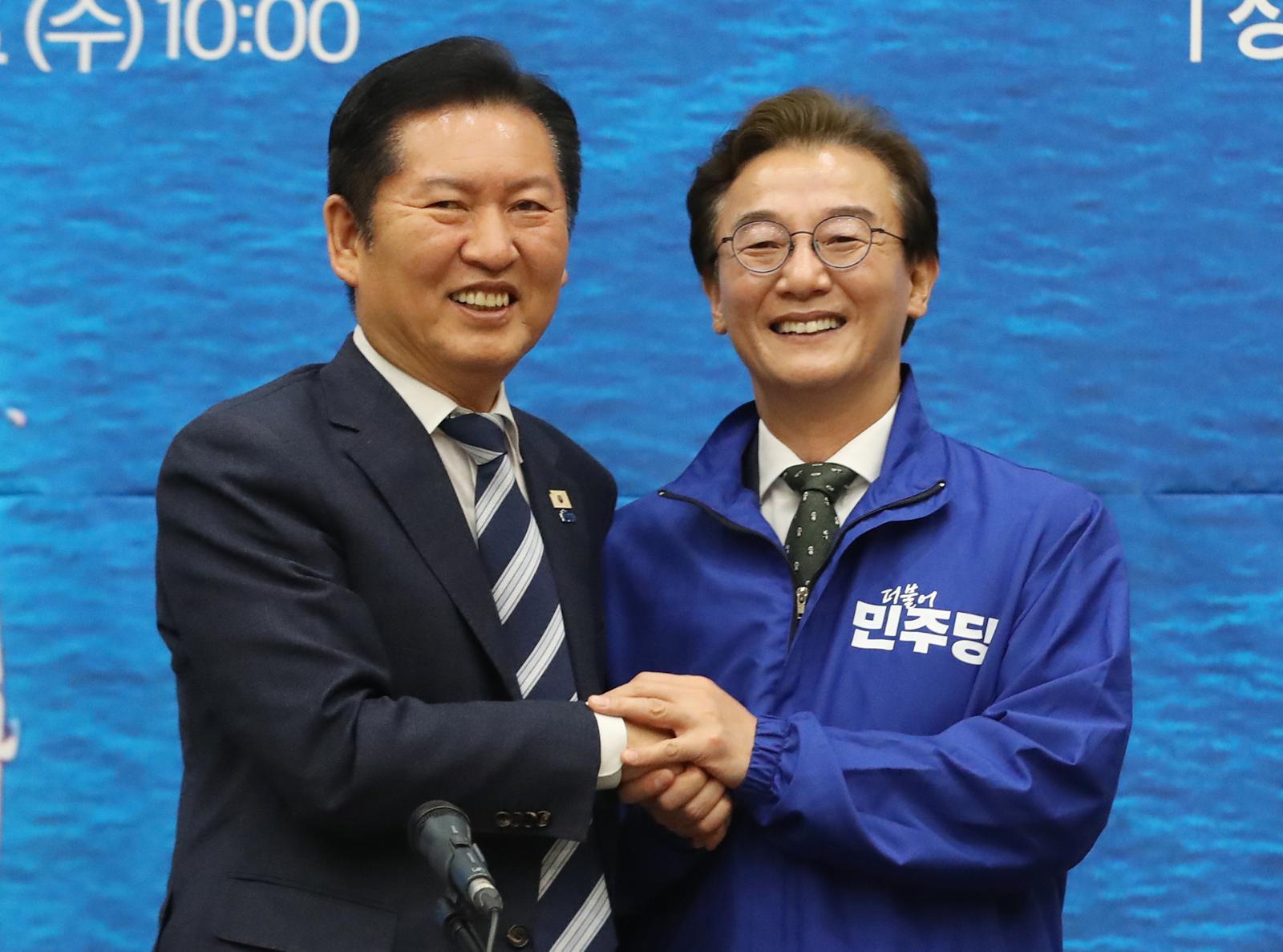 정청래 더불어민주당 대표가 부산 동구 부산항국제전시컨벤션센터에서 열린 부산 현장 최고위원회의에서 전재수 부산시장 후보에게 당 점퍼를 입혀준 뒤 기념촬영을 하고 있다. 2026.4.15/뉴스1