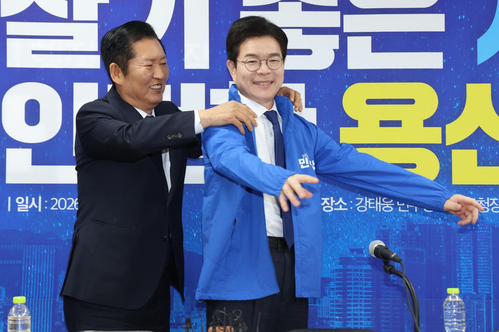 정청래 더불어민주당 대표가 17일 오전 서울 용산구 강태웅 용산구청장 후보 사무소에서 열린 현장 최고위원회의에서 정원오 서울시장 후보에게 당 점퍼를 입혀주고 있다. 뉴스1