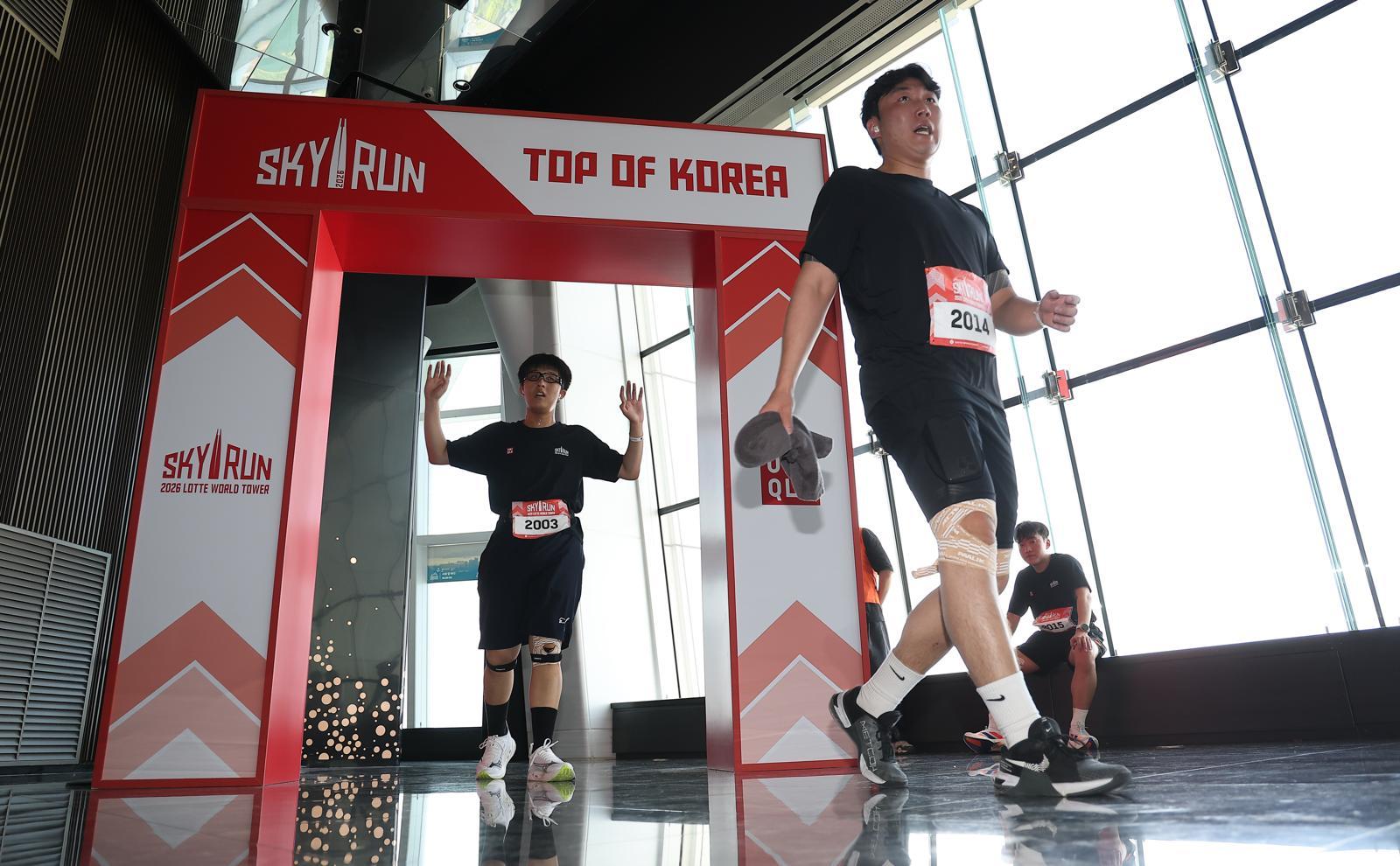 19일 서울 송파구 롯데월드타워에서 열린 수직 마라톤 대회 ‘2026 롯데월드타워 스카이런’ 행사에서 참가자들이 결승선을 지나고 있다.사진공동취재단