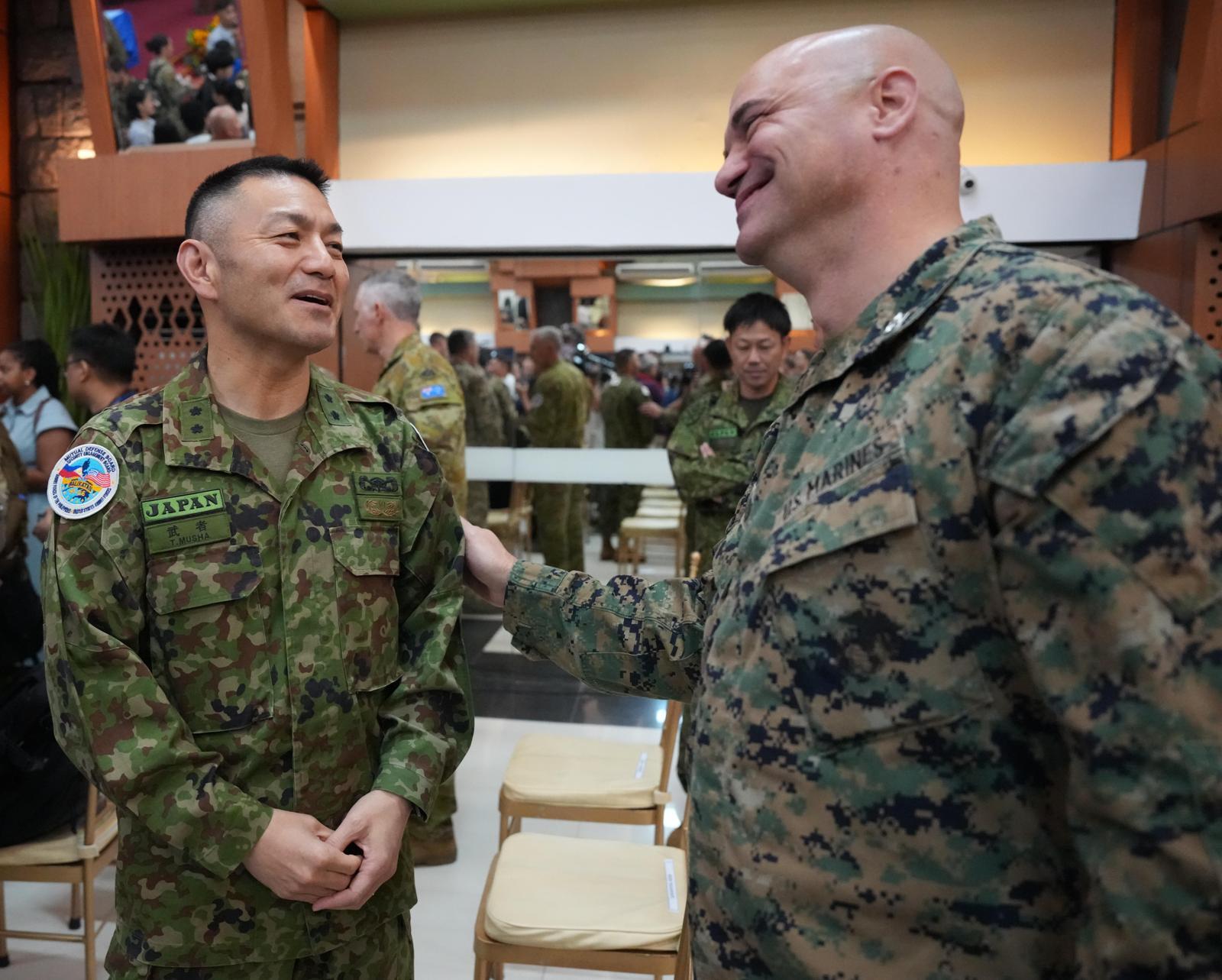 20일 필리핀 케손에서 열린 다국적 연합훈련 ‘발리카탄’ 개막식에서 무샤 도시카쓰 일본 육상자위대 수륙양용신속배치여단장(왼쪽)이 미 해병대 장교와 대화하고 있다. 케손=AP 뉴시스