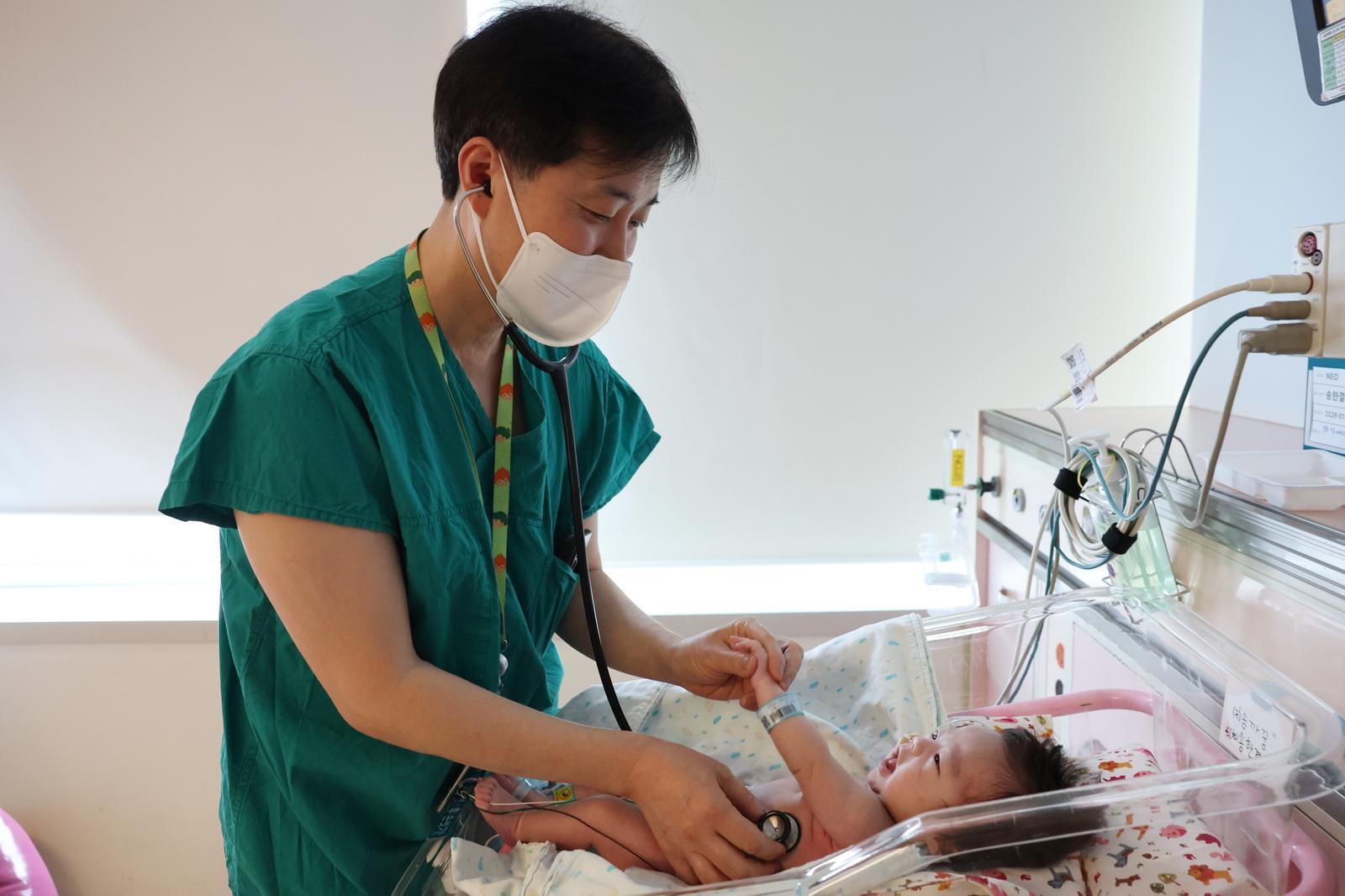 서울아산병원은 선천성 폐 기형으로 폐가 2배 부푼 신생아 한결이(남)를 에크모 보조하에 수술하는 데 성공했다. 사진은 지난 달 이병섭 신생아과 교수가 퇴원을 앞둔 한결이를 진료하는 모습. 서울아산병원 제공