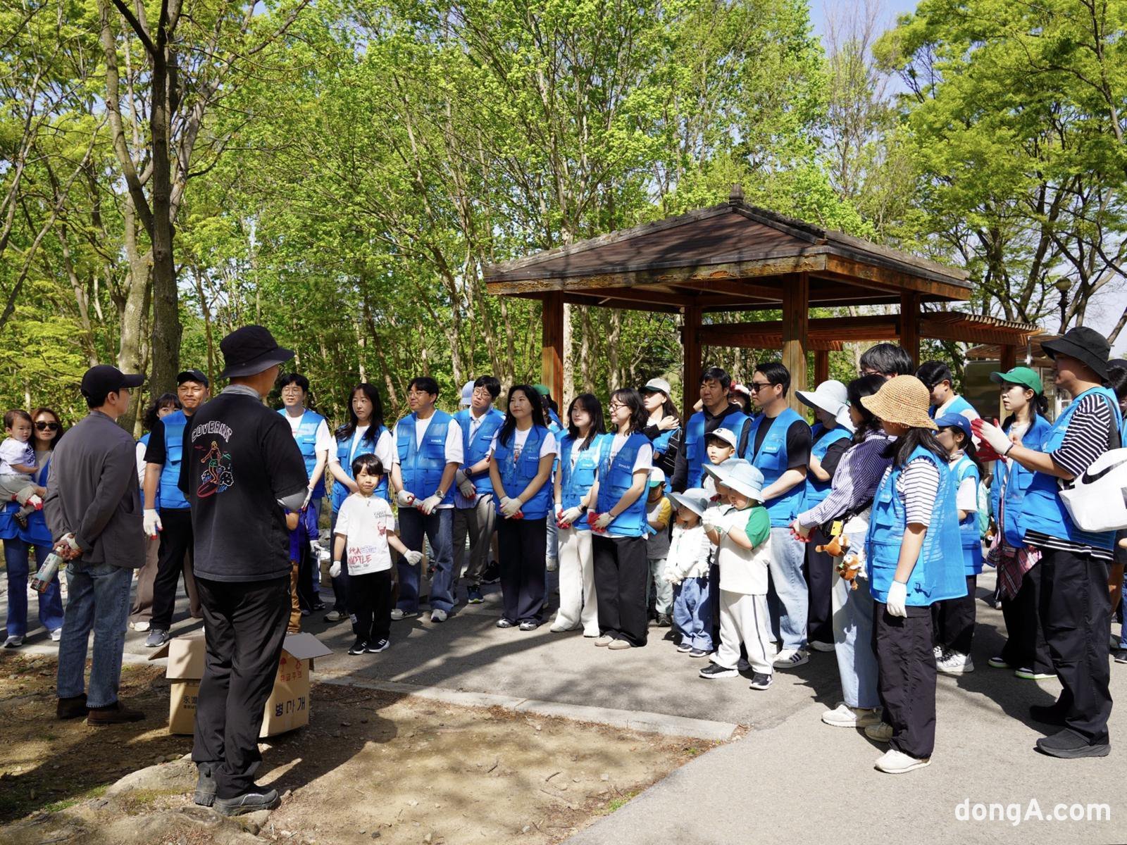 HK이노엔 임직원과 가족들이 멸종위기종 레서판다 먹이숲 조성 활동에 참여해 관련 설명을 듣고 있다. HK이노엔 제공