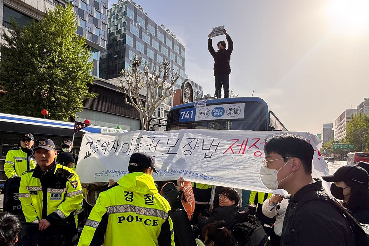 전장연, 출근길 버스지붕 위 올라가 시위