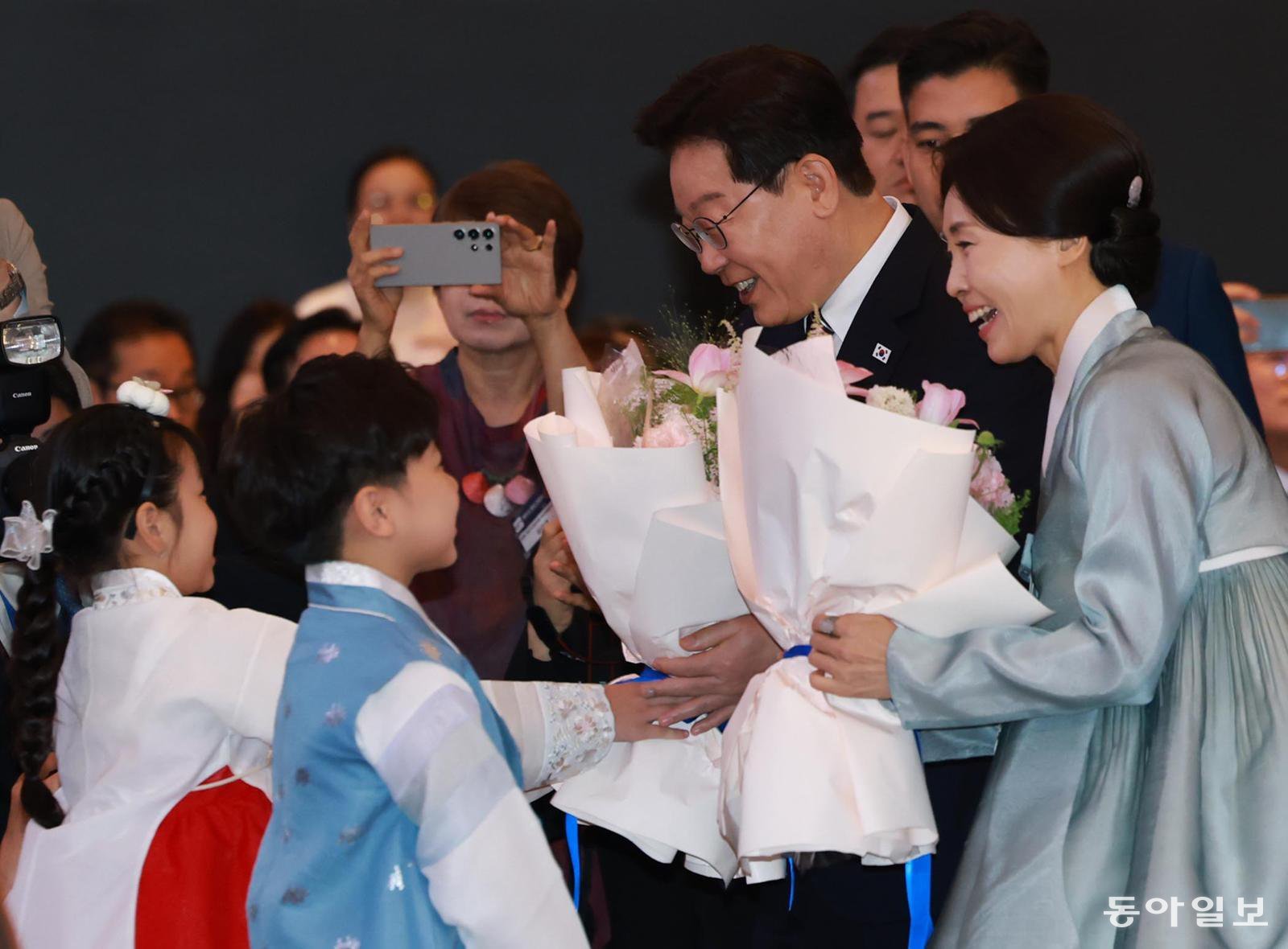 베트남을 국빈 방문 중인 이재명 대통령과 김혜경 여사가 22일 하노이의 한 호텔에서 열린 동포 오찬 간담회에서 화동으로부터 꽃다발을 받고 있다. 하노이=김재명 기자 base@donga.com