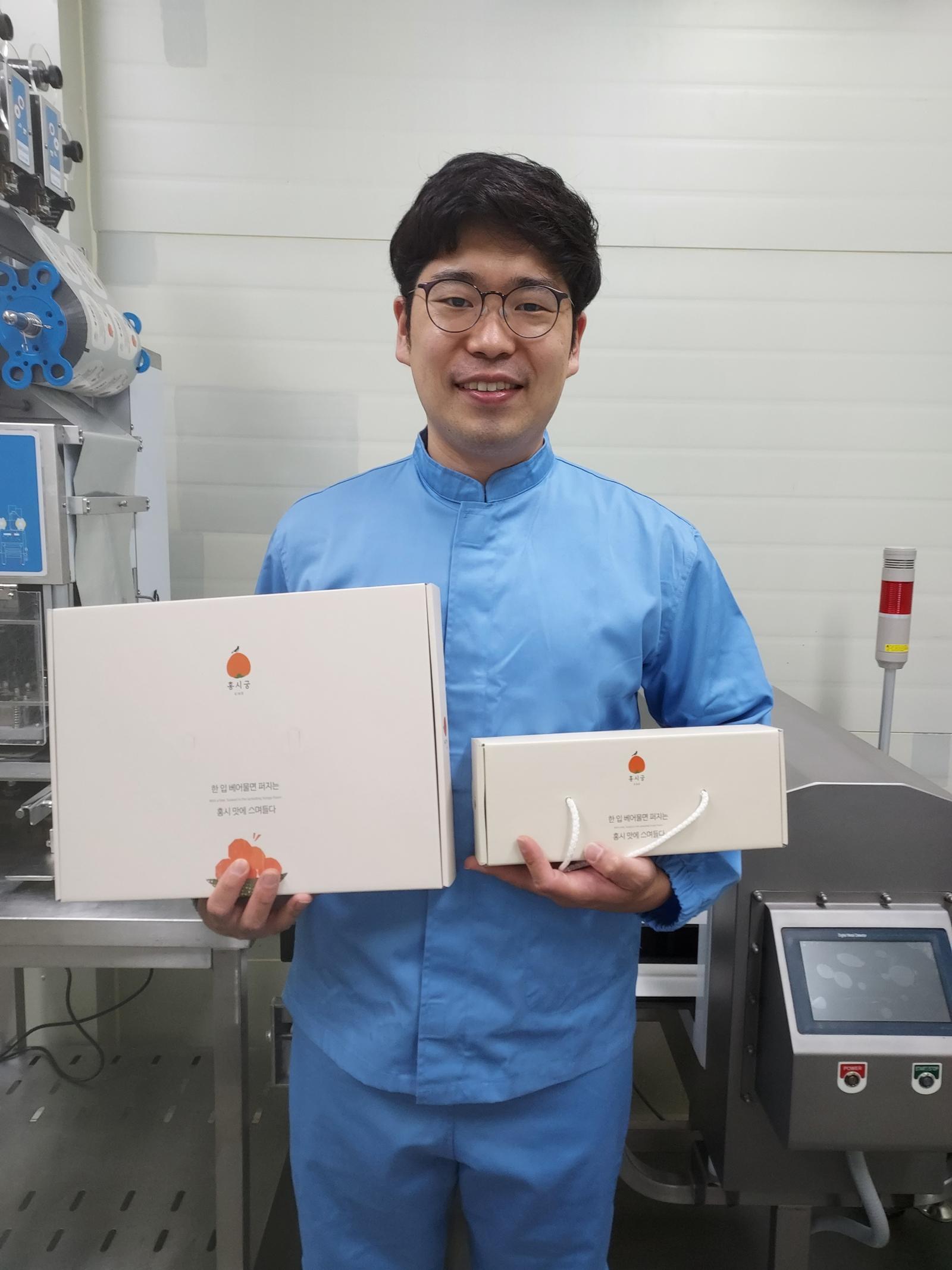 홍시 전문 브랜드 ‘홍시궁’의 유진솔 대표가 홍시찹쌀떡 선물세트를 들어 보이고 있다. 2014년 전북 전주남부시장 야시장에서 시작한 홍시궁은 홍시화채, 홍시크림떡 등 홍시를 활용한 다양한 제품을 개발한 사회적 기업이다.