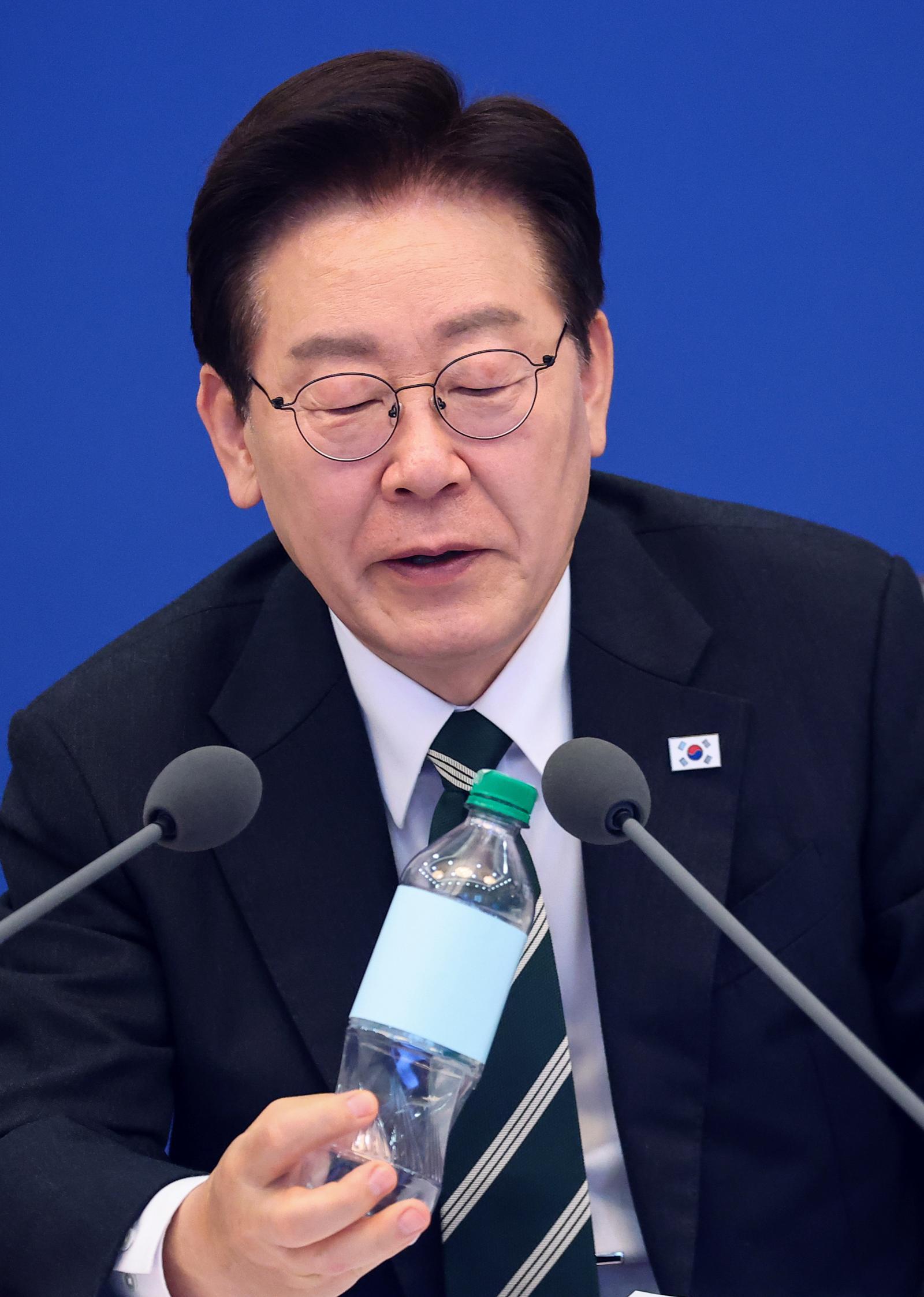 이재명 대통령이 28일 청와대에서 열린 국무회의 겸 비상경제점검회의에서 재생원료를 100% 사용한 페트병을 살펴보고 있다. 뉴스1