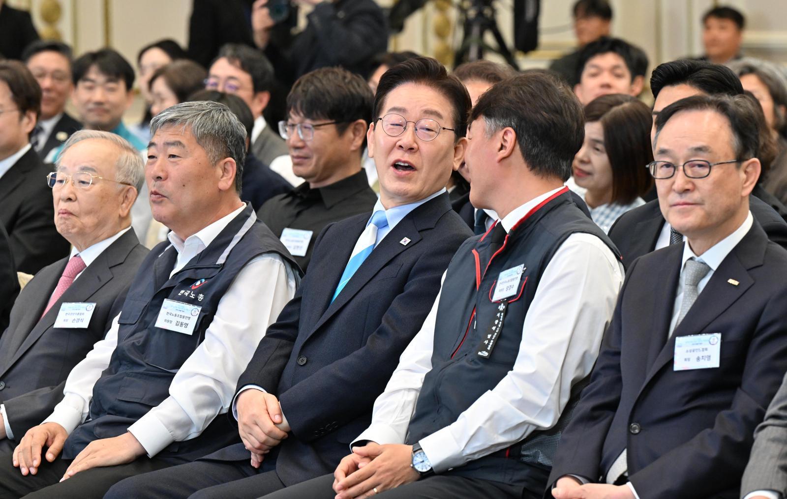 이재명 대통령이 1일 청와대 본관에서 열린 2026 노동절 기념식에 입장하며 양경수 전국민주노동조합총연맹 위원장과 이야기를 나누고 있다./2026.5.1. 청와대사진기자단