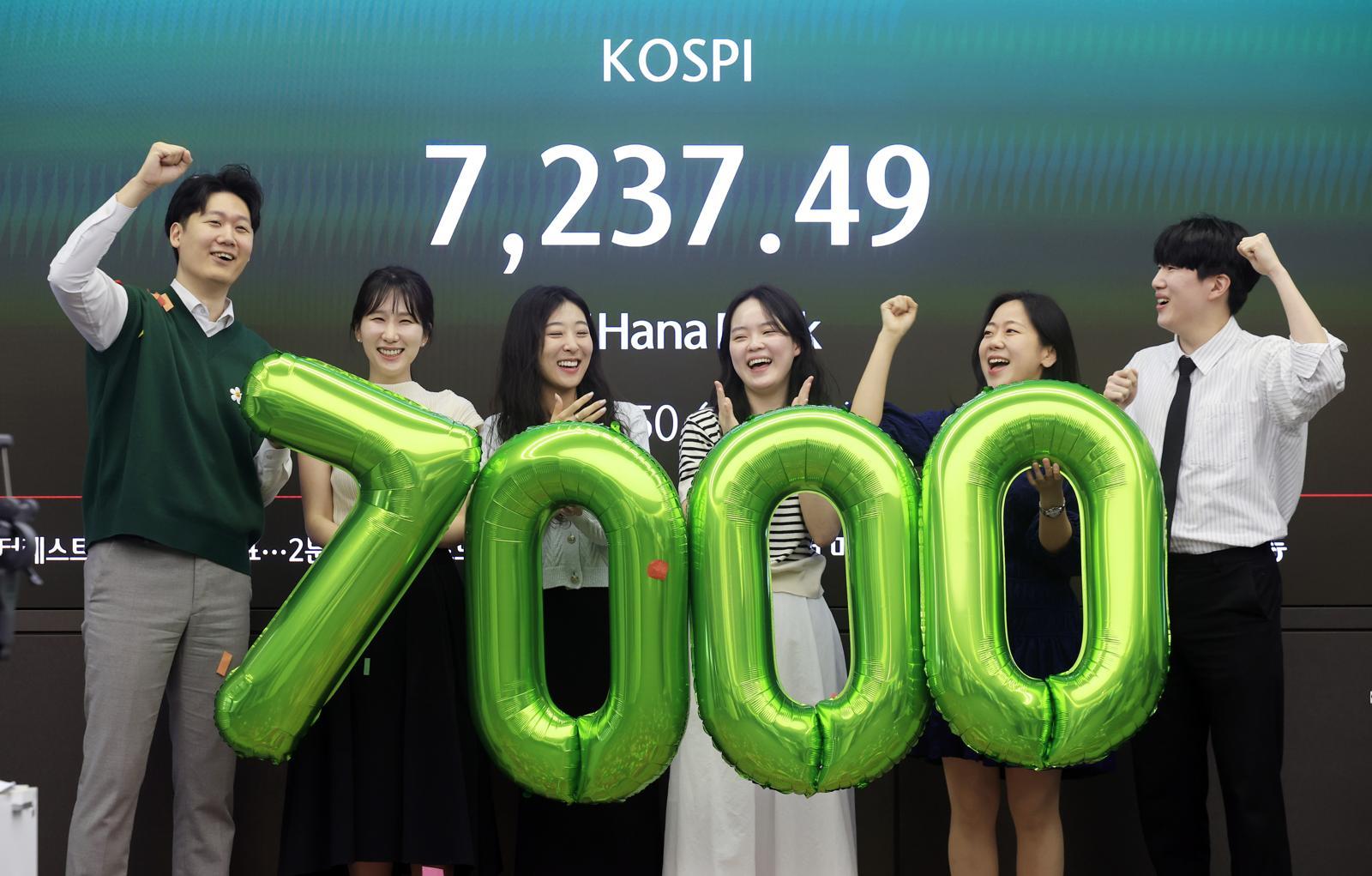 코스피가 7000을 돌파한 6일 서울 중구 하나은행 딜링룸에서 직원들이 7000 돌파 세리머니를 하고 있다. 뉴시스