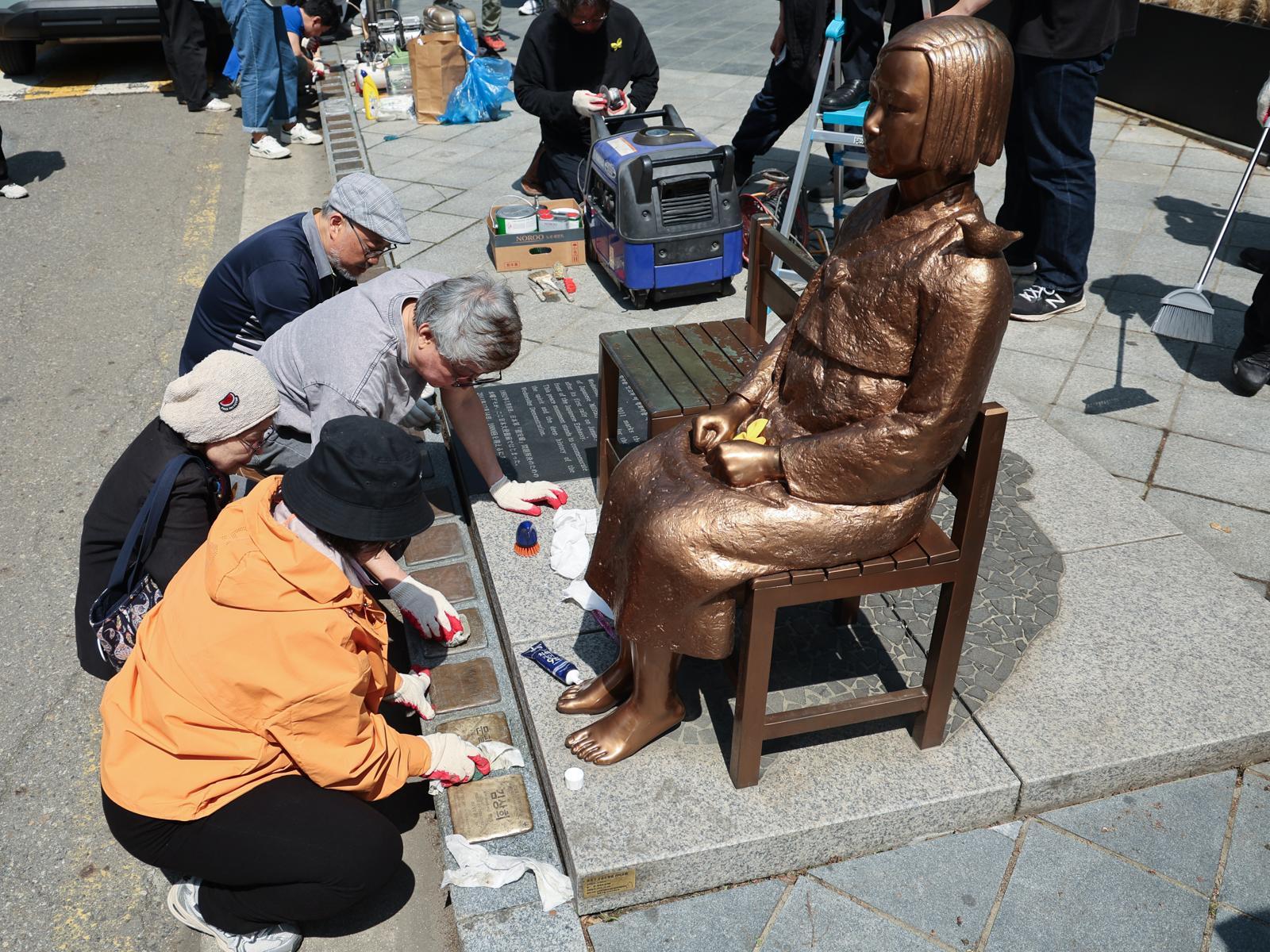 6일 서울 종로구 옛 주한 일본대사관 앞 평화의 소녀상에서 제작자와 관계자들이 보수 작업을 하고 있다. 소녀상을 둘러싼 경찰 바리케이드는 이날 6년만에 철거됐다. 뉴스1
