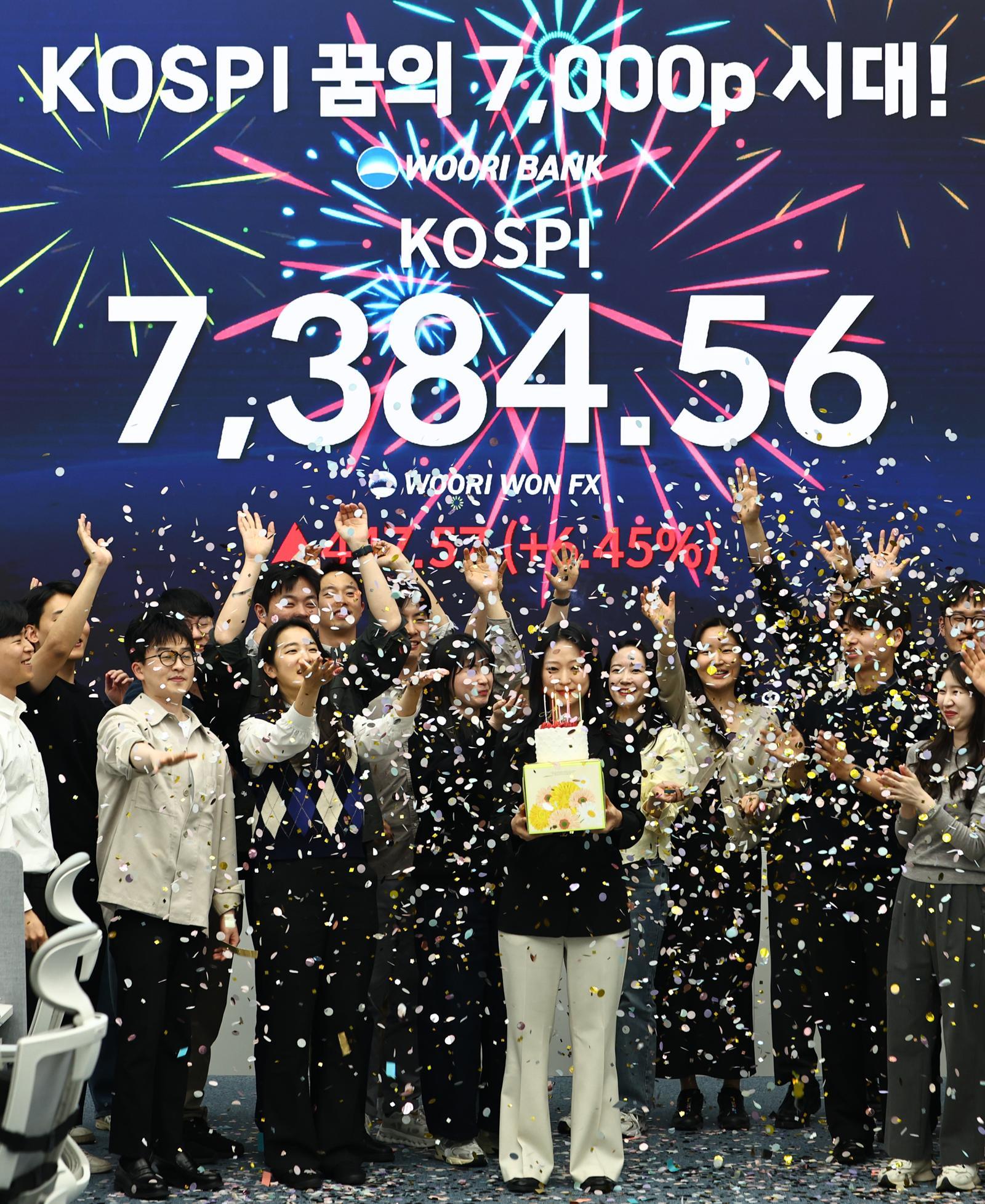 코스피가 7384.56으로 사상 최대치 마감한 6일 오후 서울 중구 우리은행 딜링룸에서 직원들이 축하 세리머니를 하고 있다. 2026.05.06 서울=뉴시스