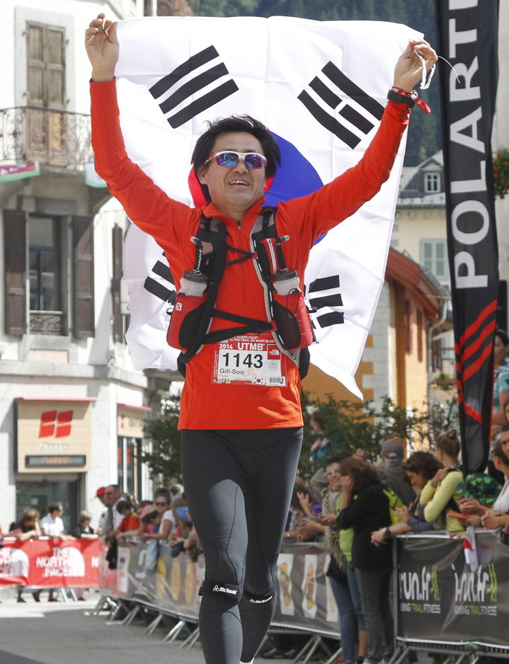 박길수 유니에버 대표가 2014년 세계 최고의 트레일러닝대회인 UTMB(울트라트레일몽블랑) 100마일에 참가해 태극기를 들고 결승선을 향해 뛰고 있다. 1998년 체중 감량을 위해 달리기 시작한 그는 2004년부터 트레일러닝에 빠져 전 세계 대회를 섭렵하고 있다. 박길수 대표 제공