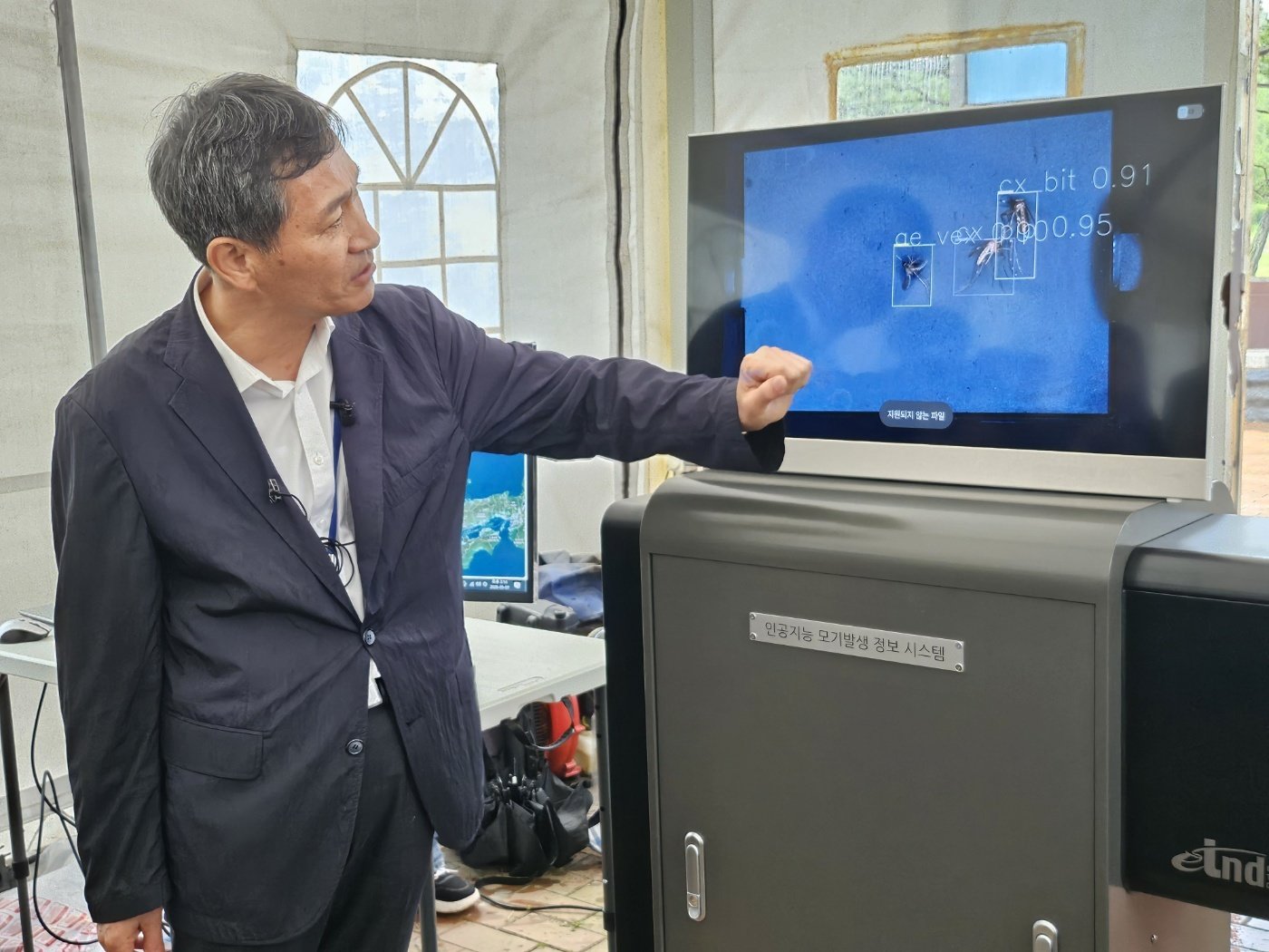 이희일 질병청 매개채분석과장이 ‘인공지능 모기 자동감시장비(AI-DMS)’ 모니터를 보며 채집된 모기에 대해 설명하고 있다. 파주=뉴스1