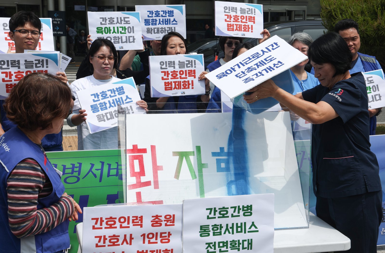공공운수노조 의료연대본부와 행동하는 간호사회 회원들이 12일 서울 종로구 서울대학교병원 본관 앞에서 열린 ‘인력 늘려! 환자 지켜! 5.12 국제 간호사의 날 기자회견’에서 모래를 부어 환자 행복을 위하는 상징 의식을 하고 있다. 2026.5.12 뉴스1