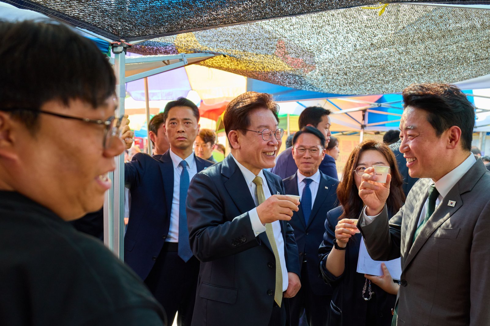 이재명 대통령이 14일 경기 성남 모란시장을 방문해 강훈식 비서실장과 시식을 하며 대화하고 있다. 청와대 제공