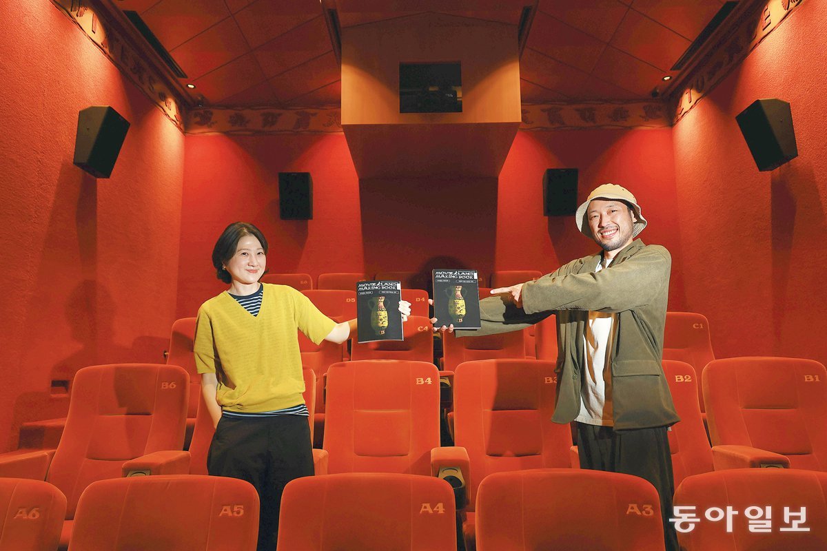 13일 서울 성동구 무비랜드에서 극장주 부부인 소호(왼쪽)와 모춘이 책 ‘무비랜드 메이킹북’을 들고 있다. 소호는 “망하기 전에 기록을 남기고 싶었다”고 했고, 모춘은 “구질구질하고 부끄러운 모습까지 담는 게 우리다운 기록”이라며 웃었다. 전영한 기자 scoopjyh@donga.com