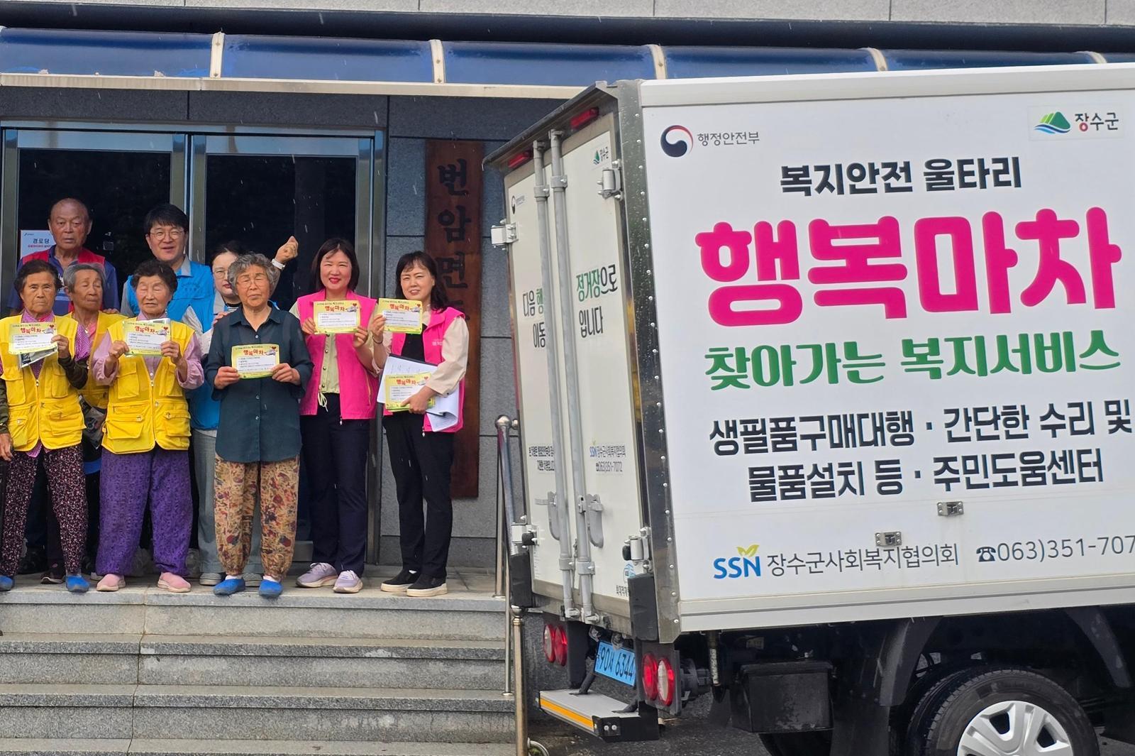 전북 장수군의 한 마을 주민들이 생활필수품 구매 대행과 고독사 예방을 위한 안부 확인 등의 역할을 하는 ‘행복마차’ 옆에서 기념사진을 찍고 있다. 장수군 제공