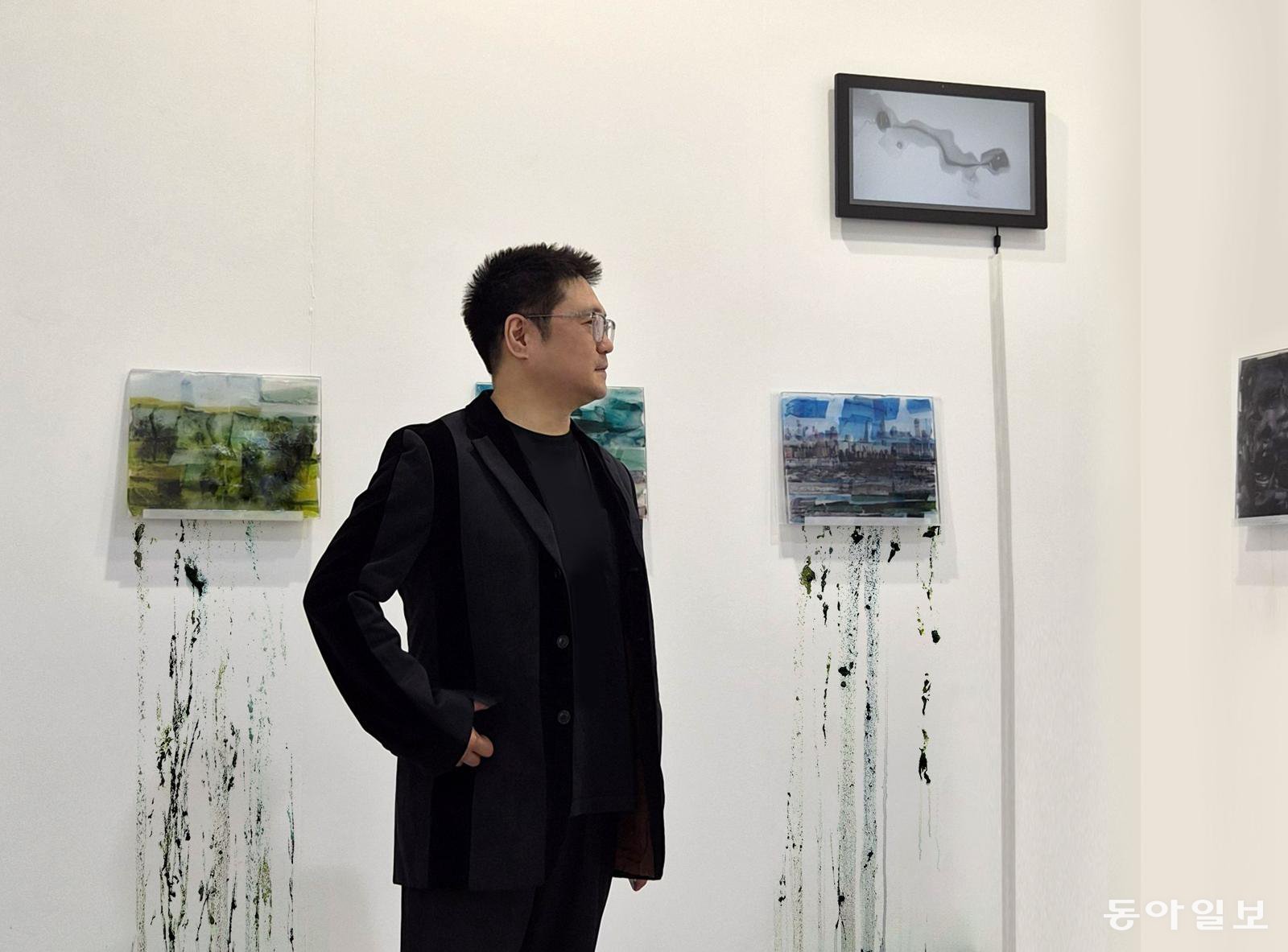 ‘2026 홍콩 아트센트럴’ 전시장에서 녹아내리고 있는 얼음 작품 ‘Frozenism’ 앞에 서 있는 성서 작가.