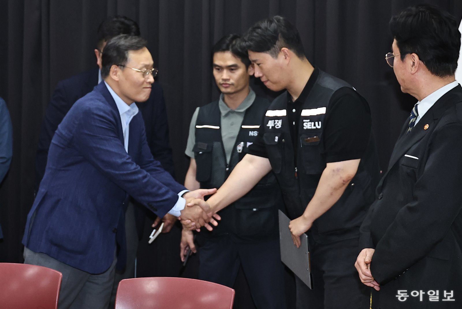 20일 경기 수원시 영통구 중부지방고용노동청 경기지청에서 열린 삼성전자 노사 추가 교섭에서 노사가 잠정합의안을 마련한 뒤 여명구 삼성전자 DS부문 피플팀장(오른쪽)과 최승호 삼성전자 초기업노조 삼성전자지부 위원장이 손을 잡고 파이팅을 외치고 있다. 수원= 양회성 기자