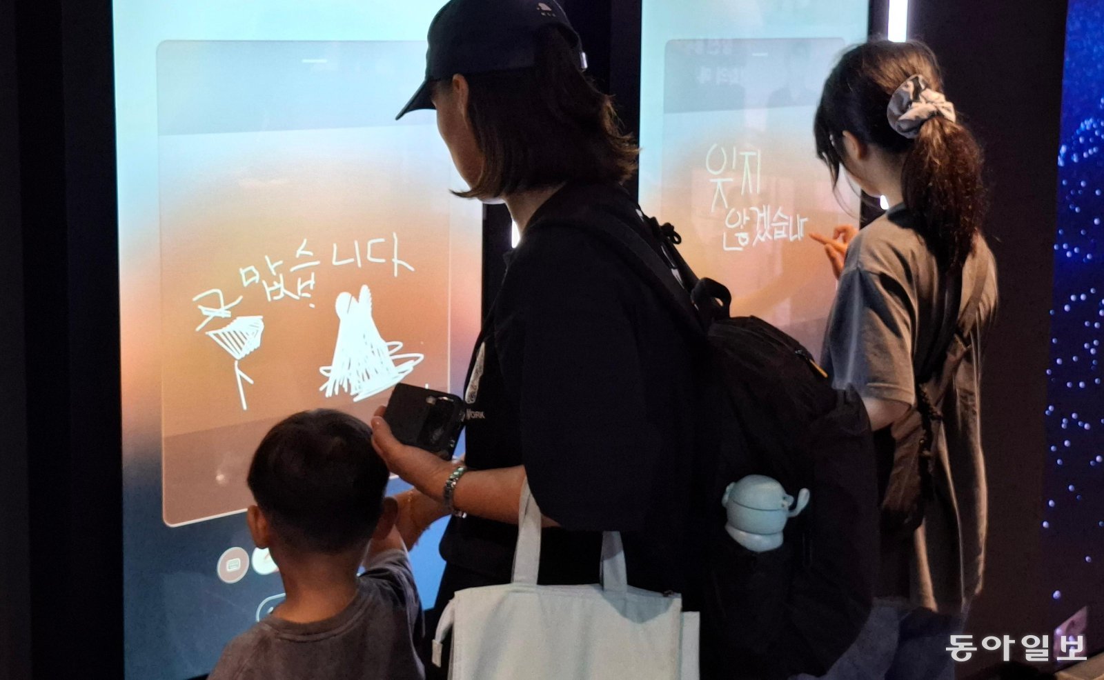 19일 오후 프리덤홀을 방문한 시민들이 ‘감사의 아카이빙 월’ 터치스크린에 참전용사를 추모하는 메시지를 남기는 모습. 송진호 기자 jino@donga.com
