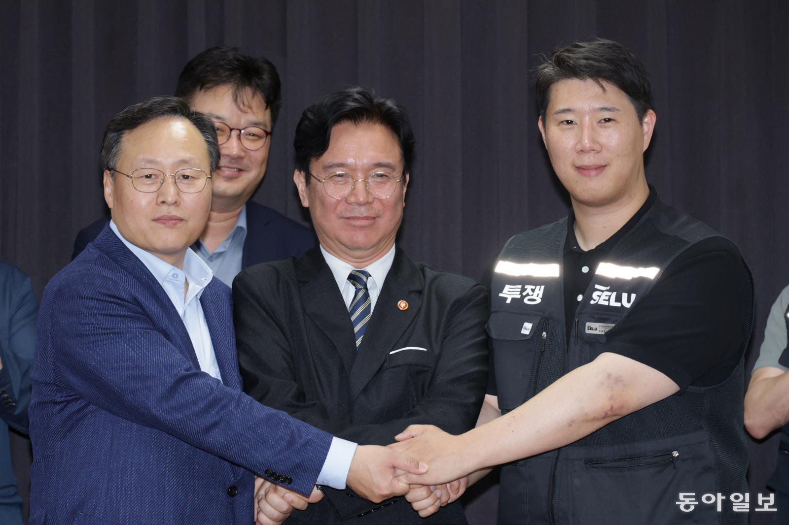 20일 경기도 수원시 장안구 경기고용노동청에서 열린 삼성전자 임금협상을 마친 후 여명구 삼성전자 DS(디바이스솔루션·반도체 사업 담당) 피플팀장과 김영훈 고용노동부 장관, 최승호 삼성그룹 초기업노동조합 삼성전자지부 위원장이 잠정 합의한에 서명한 후 손을 맞잡고 있다. 수원=양회성 기자 yohan@donga.com