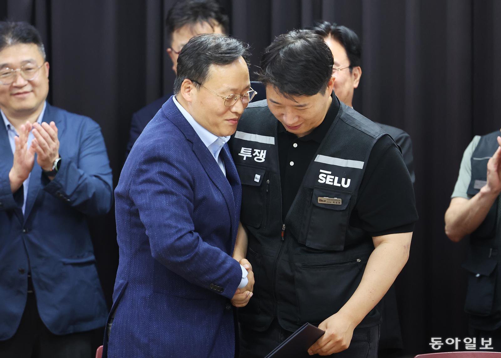 20일 경기도 수원시 장안구 경기고용노동청에서 열린 삼성전자 임금협상을 마친 후 여명구 삼성전자 DS(디바이스솔루션·반도체 사업 담당) 피플팀장과 최승호 삼성그룹 초기업노동조합 삼성전자지부 위원장이 잠정 합의한에 서명한 후 손을 맞잡고 있다. 양회성 기자 yohan@donga.com