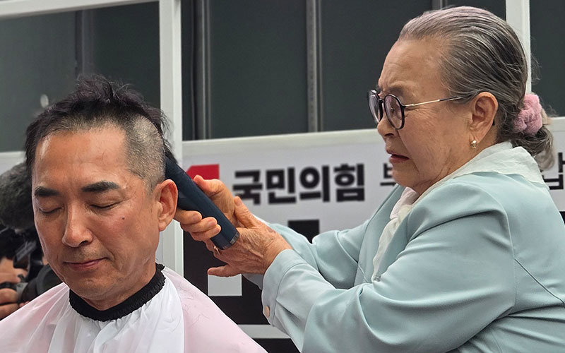 박민식 국민의힘 부산 북구갑 국회의원 보궐선거 후보가 공식 선거운동 첫날인 21일 오후 부산 북구 구포시장 인근 쌈지공원에서 열린 출정식에서 삭발을 하고 있다. 2026.5.21/뉴스1