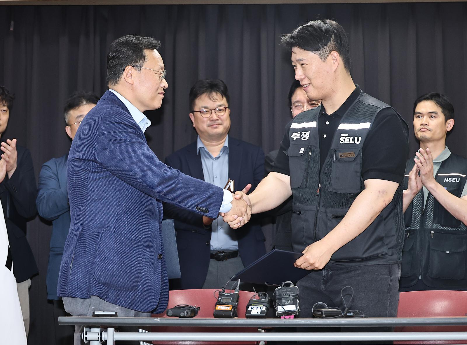 20일 경기 수원시 장안구 경기고용노동청에서 열린 삼성전자 임금협상을 마친 후 여명구 삼성전자 DS(디바이스솔루션·반도체 사업 담당) 피플팀장과 최승호 삼성그룹 초기업노동조합 삼성전자지부 위원장이 악수를 하고 있다. 2026.5.20. 뉴스1