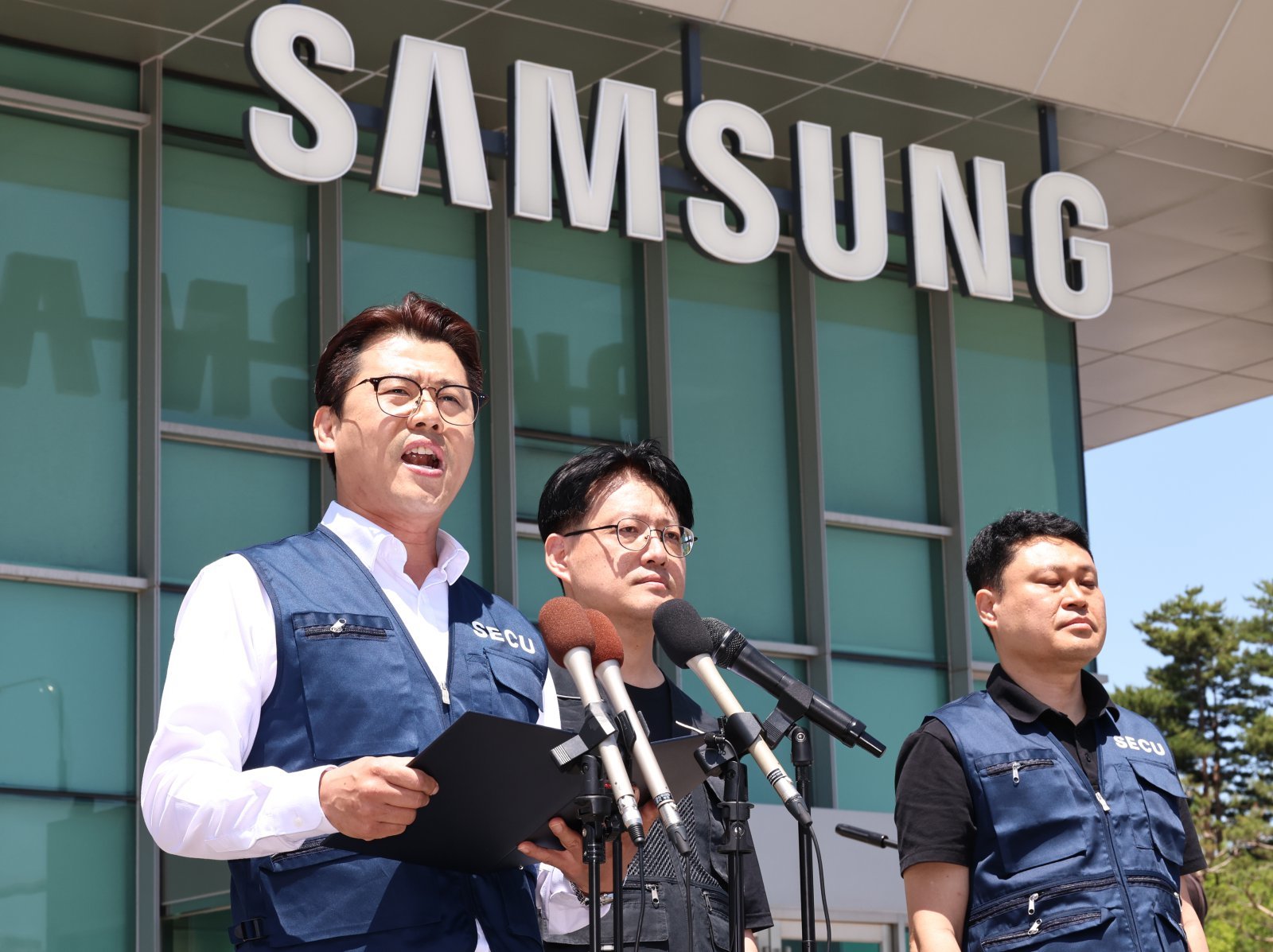 삼성전자 디바이스경험(DX) 부문 직원들이 주축인 삼성전자노동조합(SECU·동행노조)과 전국삼성전자노동조합(NSEU) 수원지부 집행부가 22일 오후 경기 수원 영통구 삼성전자 정문 앞에서 삼성전자 노사 임금협상 잠정합의안 찬반 투표 시작을 앞두고 입장을 밝히고 있다. 2026.05.22 [수원=뉴시스]