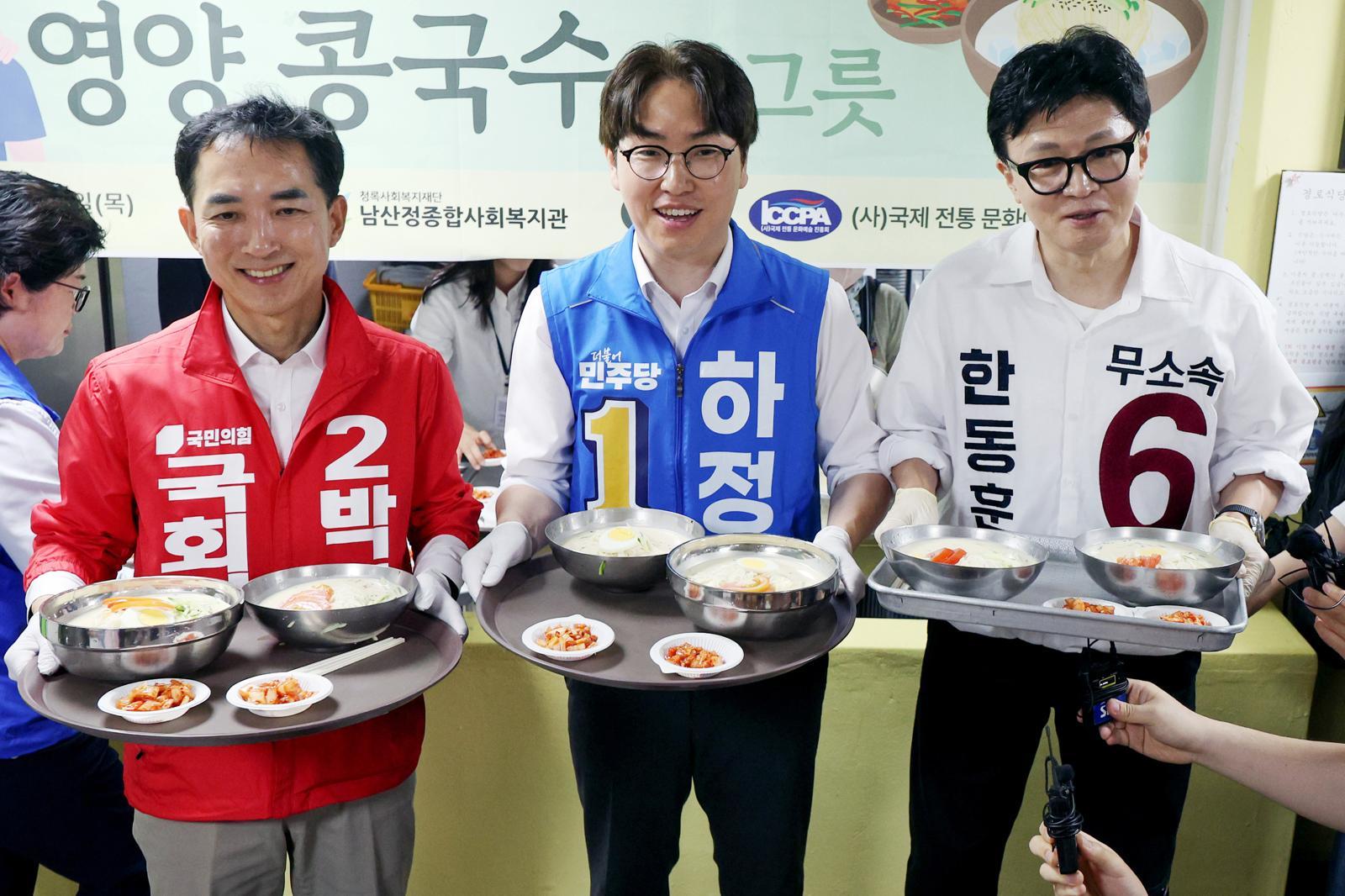 제9회 전국동시지방선거 및 국회의원 재·보궐선거의 공식 선거운동이 시작된 21일 부산 북구갑 국회의원 보궐선거 국민의힘 박민식(왼쪽부터), 더불어민주당 하정우, 무소속 한동훈 후보가 부산 북구 남산정복지관에서 열린 콩국수 나눔행사에서 콩국수를 나르고 있다. 2026.05.21 [부산=뉴시스]