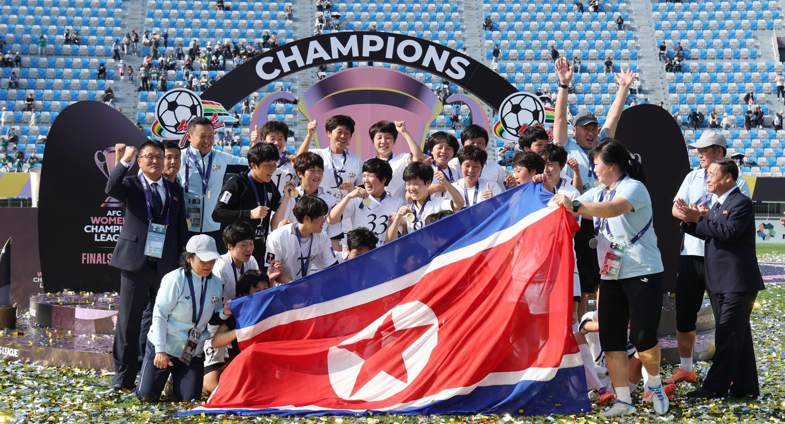 북한 내고향여자축구단 선수들이 23일 경기 수원시 수원종합운동장에서 아시아축구연맹(AFC) 여자 챔피언스리그 우승을 거둔 뒤 인공기를 펼친 채 기념 촬영을 하고 있다. 수원=뉴스1