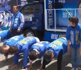 24일 전남 광양시 옥곡5일장에서 열린 더불어민주당 광양시장과 지방의회 후보 합동 유세 현장에서 선거대책위원회 소속 한 지지자가 마이크를 잡고 후보들에게 “엎드려뻗쳐”를 지시하자 일부 후보들이 바닥에 엎드리고 있다. 델리민주 유튜브 화면 캡처