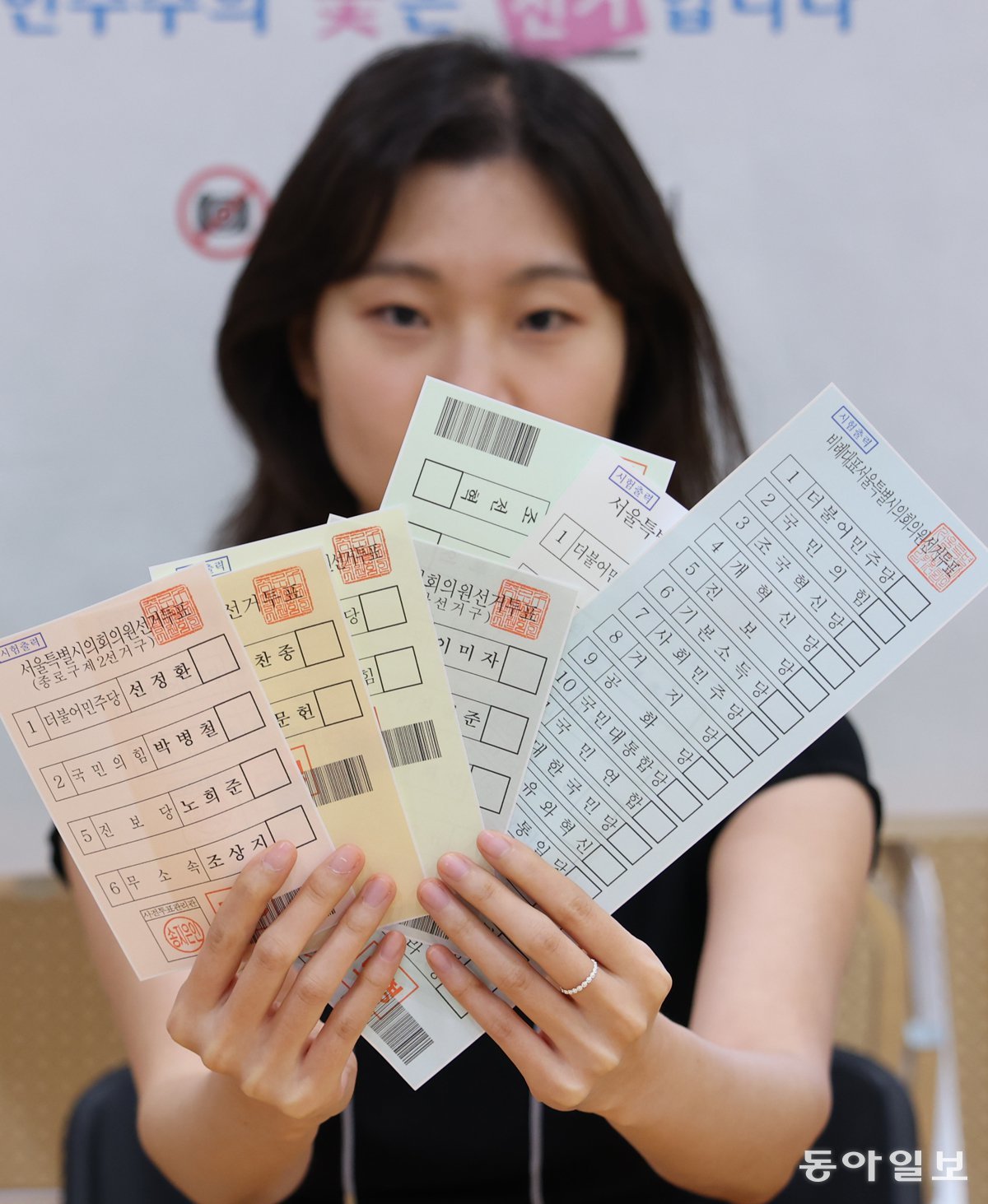 사전투표를 하루 앞둔 28일 서울 종로구 종로 1·2·3·4가동 주민센터에 마련된 사전투표소에서 선관위 관계자가 모형 투표용지를 들어 보이고 있다. 송은석 기자 silverstone@donga.com