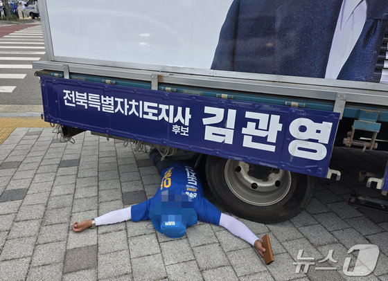 1일 오전 8시 30분께 전북 전주시 효자동의 한 사거리에서 무소속 김관영 전북지사 후보 유세차 밑에 이원택 후보 선거운동원이 드러누운 모습.(독자 제공) 2026.6.1 ⓒ 뉴스1