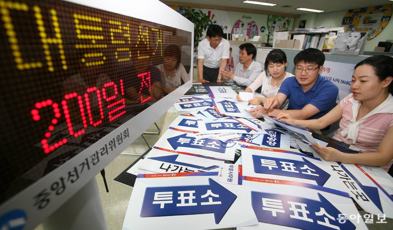〈대선 200일 앞〉 투표소 용품 디자인도 멋지게. 경기 과천시 중앙선거관리위원회 선거상황팀 직원들이 새 투표소 사무용품 디자인을 점검·토의하고 있다. (동아일보, 2007년 6월 1일, 이훈구 기자)