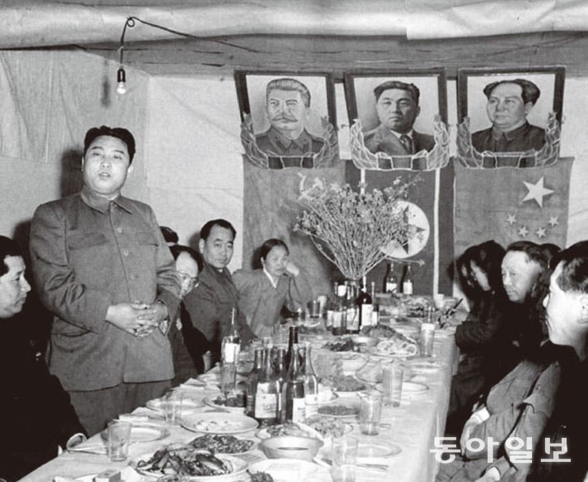 1951년 4월, 중국 간부들을 만난 김일성. 천막에 건 김일성 사진 좌우로 스탈린과 마오쩌둥의 사진이 붙어 있다. 동아일보 DB