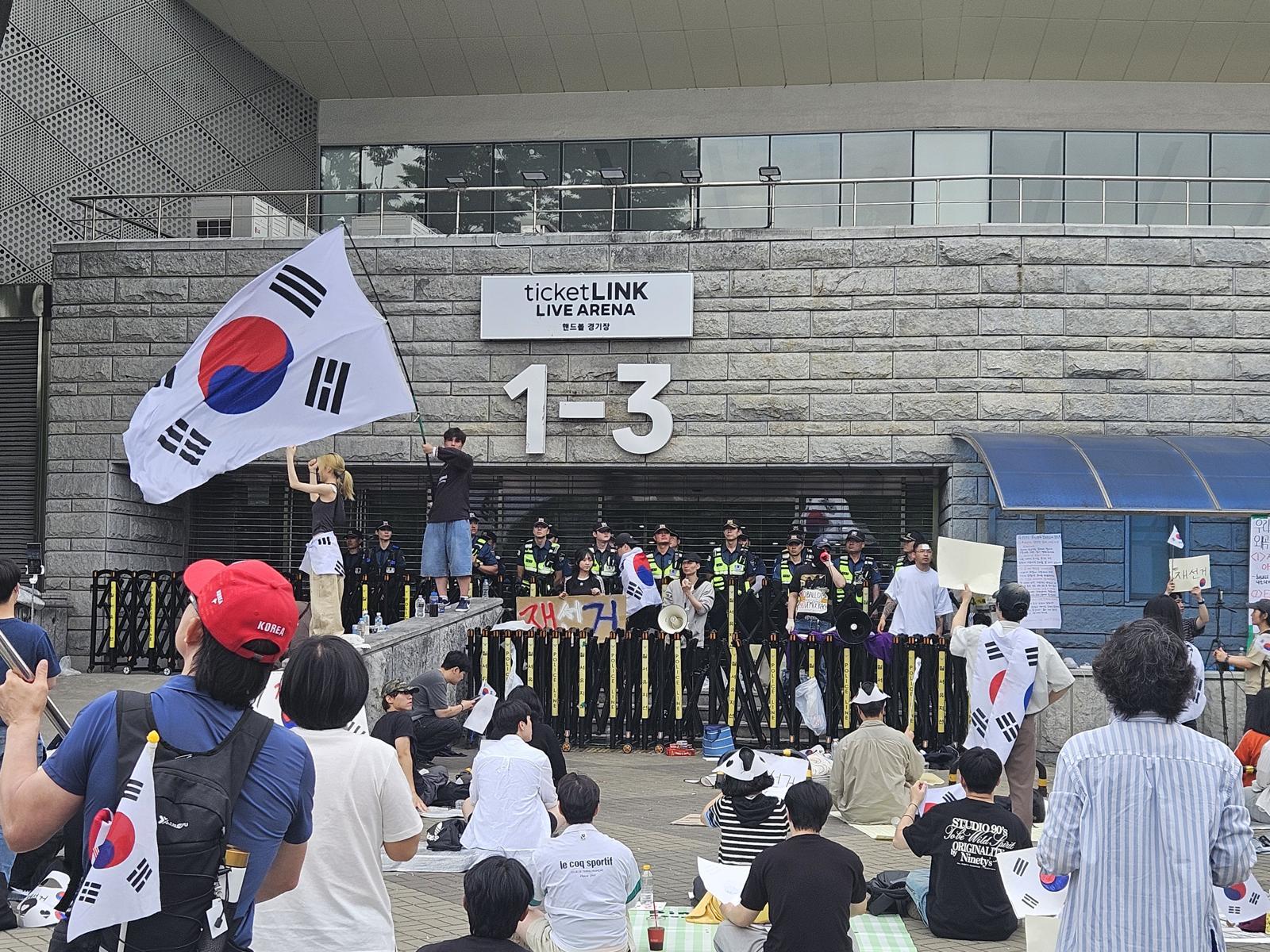 6·3 지방선거 투표용지 부족 사태에 반발한 시민들이 7일 오 서울 송파구 올림픽공원 핸드볼경기장 개표소 앞에 모여 재선거를 요구하는 구호를 외치고 있다. 2026.6.7 ⓒ 뉴스1
