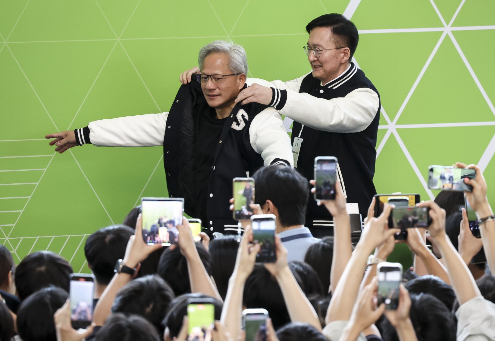 젠슨 황 엔비디아 최고경영자(CEO)가 8일 서울대학교 해동첨단공학관에서 열린 ‘빌드어클로(Build-a-Claw)’ 행사장에서 유홍림 서울대 총장으로부터 학교 점퍼를 선물받고 있다. (공동취재) 2026.6.8 ⓒ 뉴스1