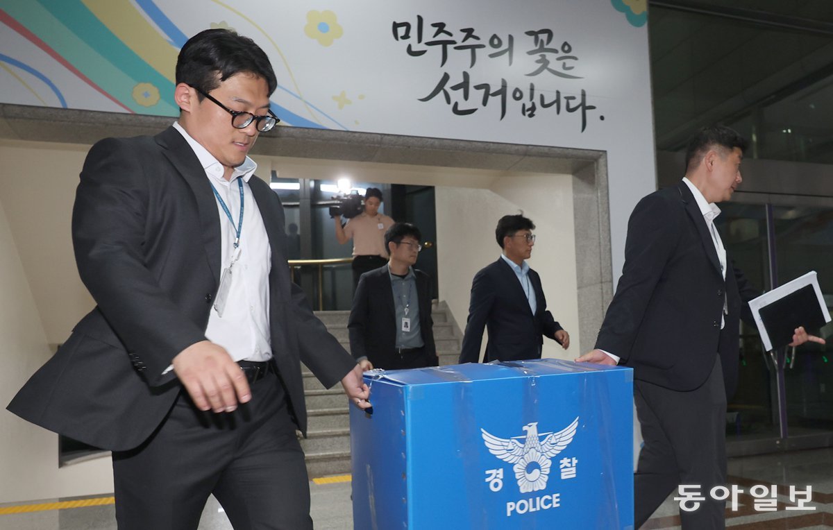 과천 중앙선관위 압수수색하는 경찰 11일 경찰 관계자가 6·3 지방선거 투표용지 부족 사태와 관련해 경기 과천시 중앙선거관리위원회를 압수수색한 뒤 압수물을 들고 나오고 있다. 경찰은 이날 중앙선거관리위원회와 서울시, 송파구 선관위 등 7곳에 수사관을 보내 투표용지 관련 자료를 확보했다. 압수수색 영장에는 노태악 전 중앙선거관리위원장 등이 공직선거법 위반 및 직무유기 혐의 피의자로 적시됐다. 과천=장승윤 기자 tomato99@donga.com