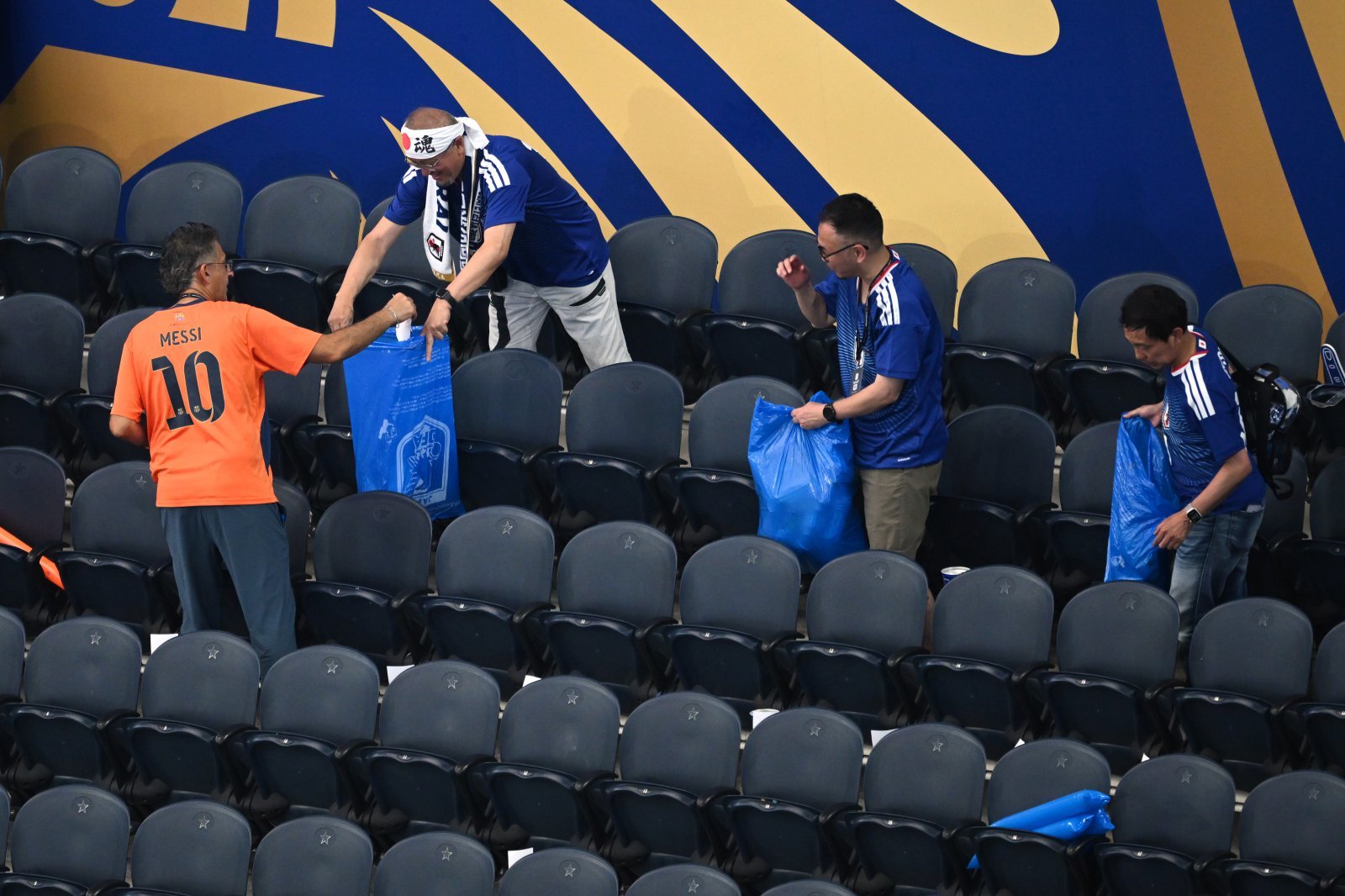 Japan fans clean up trash in the stadium following the World Cup Group F soccer match between the Netherlands and Japan in Arlington, Texas, near Dallas, Sunday, June 14, 2026. (AP Photo/Jessica Tobias)
