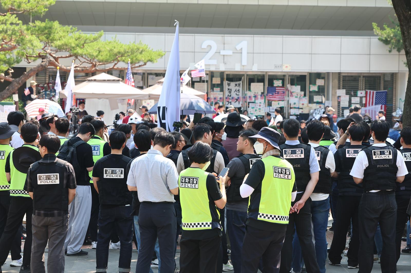 6·3 지방선거 ‘투표용지 부족 사태’로 12일째 잠실 개표소 봉쇄 시위가 이어지고 있는 16일 경찰과 대한체육회 등관계자들이 서울 송파구 올림픽공원 핸드볼경기장 진입을 시도하다 시위대와 대치하고 있다. 2026.6.16/뉴스1