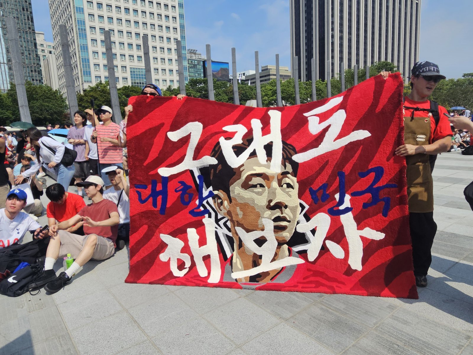 손흥민 선수 얼굴에 ‘그래도 대한민국 해보자’라고 적힌 대형 러그를 만들어 온 서윗(작가명·36·남) 씨의 모습. 2026.6.19 ⓒ 뉴스1