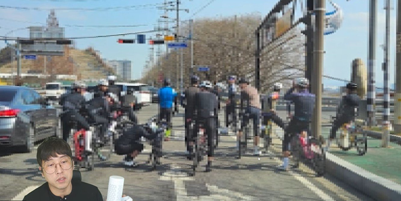 자전거 무리가 교차로에서 신호를 기다리며 우회전 차량의 진입 경로를 가로막고 있다. 사진=유튜브 드론라이더 갈무리