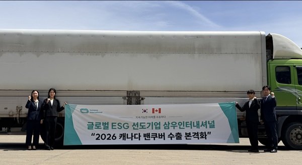 삼우인터내셔널 관계자들이 대형 트럭 앞에서 ‘2026 캐나다 밴쿠버 수출 본격화’ 기념 배너를 들고 포즈를 취하고 있다. 사진제공=삼우인터내셔널