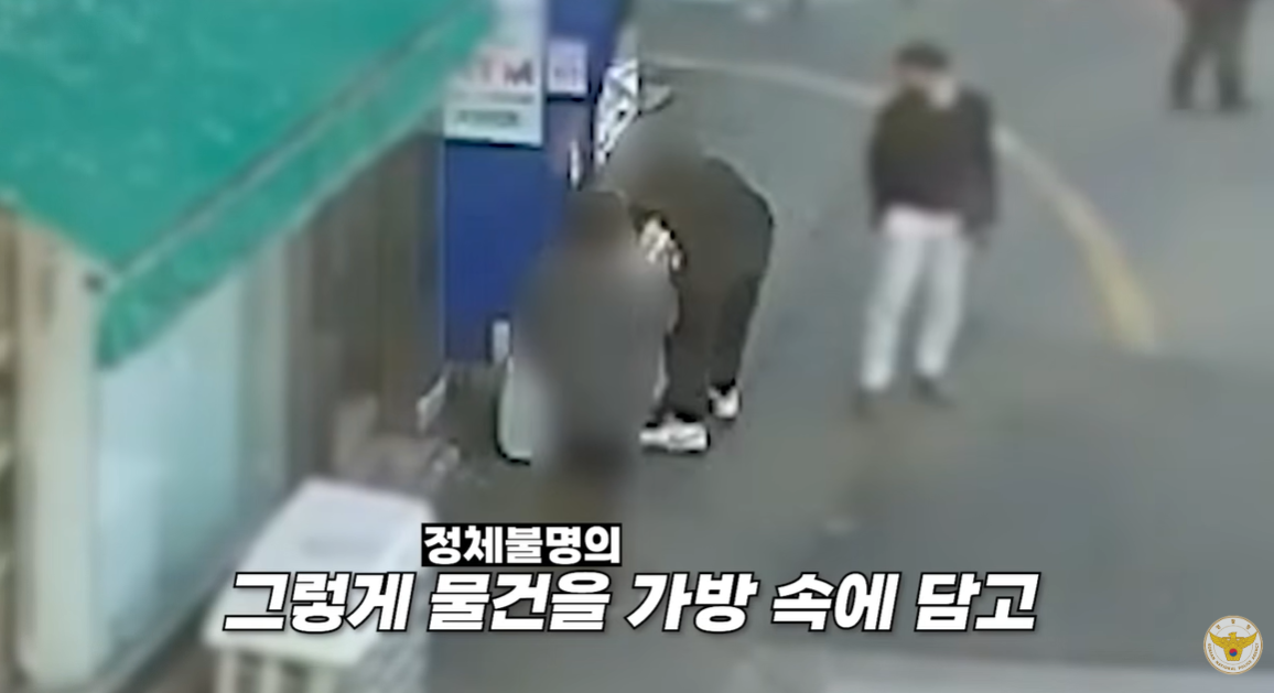 대전 동구 대전역 인근에 있는 현금인출기 앞에서 보이스피싱 피해자가 수거책에게 현금이 든 종이가방을 건네는 모습. 대전경찰청 제공