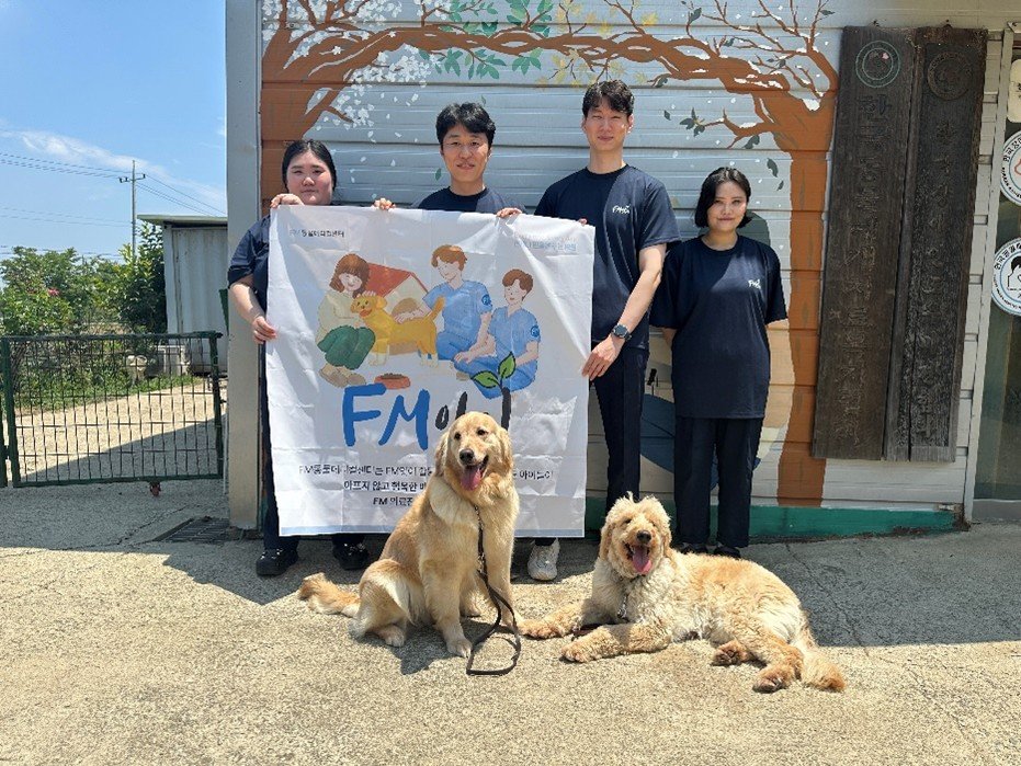 FM동물메디컬센터의 정기 봉사단 ‘FM앗이(품앗이)’멤버들이 장애인도우미견을 분양받은 청각장애인이 직접 그린 벽화 앞에서 기념촬영을 하고 있다. 사진제공=FM동물메디컬센터
