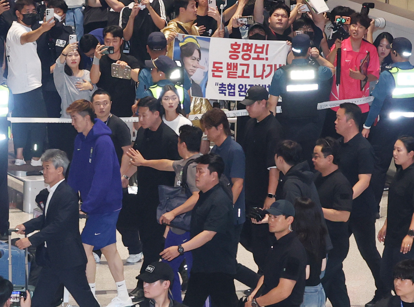 2026 북중미 월드컵 32강 진출 실패의 책임을 지고 사퇴 의사를 밝힌 홍명보 축구대표팀 감독이 30일 새벽 인천국제공항 2터미널에 도착, 축구팬들 아유를 받으며 이동하고 있다. 뉴스1