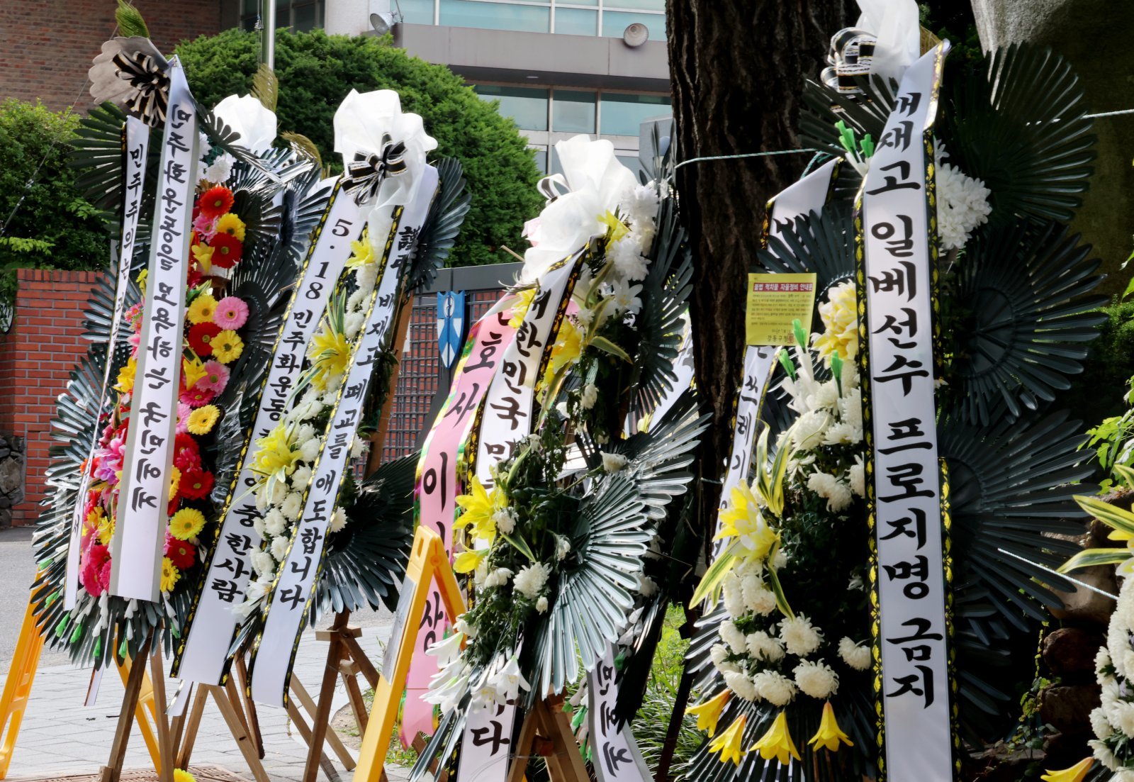 1일 오후 서울 강동구 배재고등학교 정문 앞에 근조화환이 늘어 서 있다.  지난달 29일 배재고는 청룡기 전국고교야구선수권대회 광주제일고와의 경기에서 “가야지, 가야지, 스타벅스 가야지”, “탱크 데이”등 스타벅스의 ‘5·18 탱크데이’ 논란을 연상시키는 구호를 외쳤다. 2026.07.01 [서울=뉴시스]