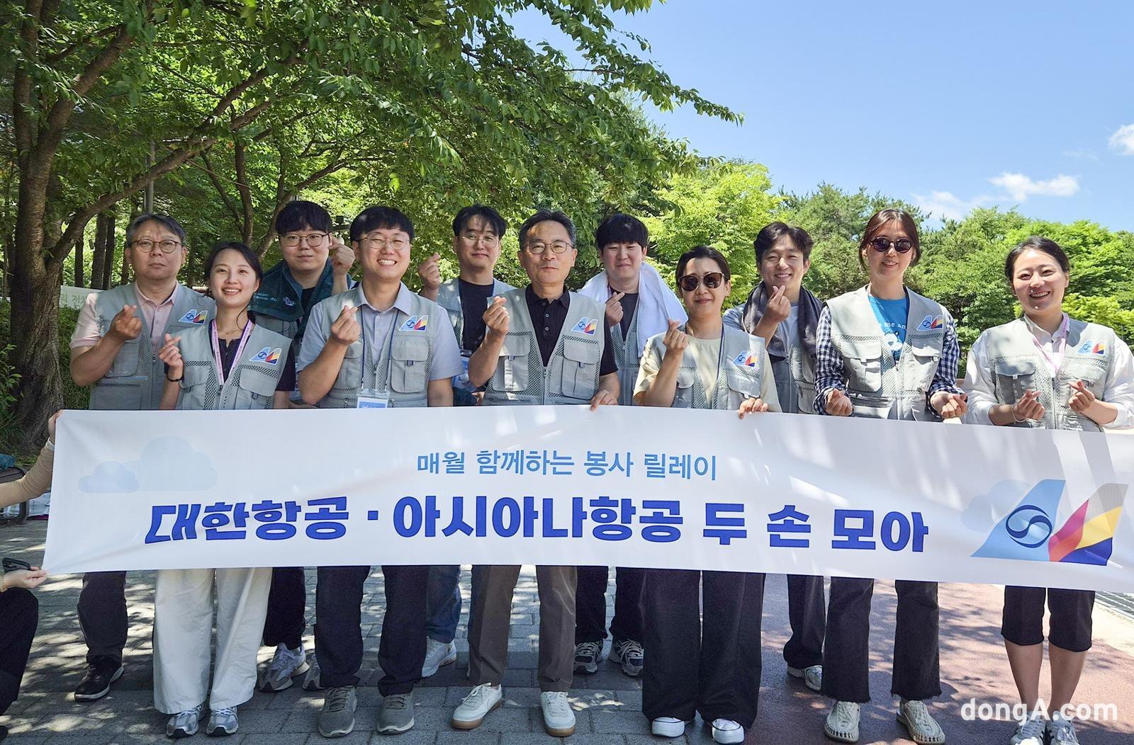 대한항공과 아시아나항공 임직원들이 서울 강서구 개화산 둘레길 일대에서 ‘두 손 모아 줍깅’ 환경정화 활동을 진행하고 기념촬영을 하고 있다. 대한항공 제공