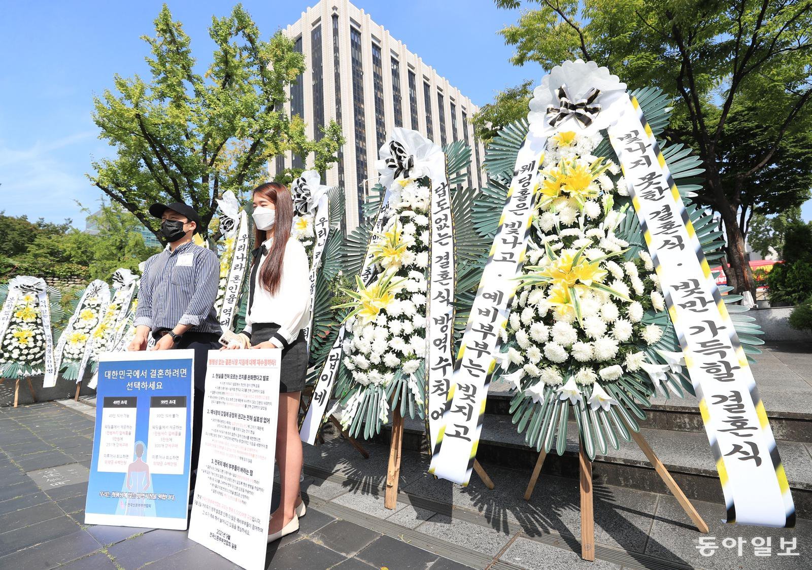 “빚지는 결혼식 될판” 거리로 나온 예비 신랑-신부
2021년 9월 9일 서울 종로구 정부서울청사 앞에서 전국신혼부부연합회 회원들이 ‘화환 시위’를 벌이고 있다. 이들은 거리 두기 3, 4단계에서 49명까지 또는 식사 제공 없이 99명까지만 참석할 수 있게 제한한 결혼식 관련 방역수칙의 개선을 요구했다. 김재명 기자 base@donga.com